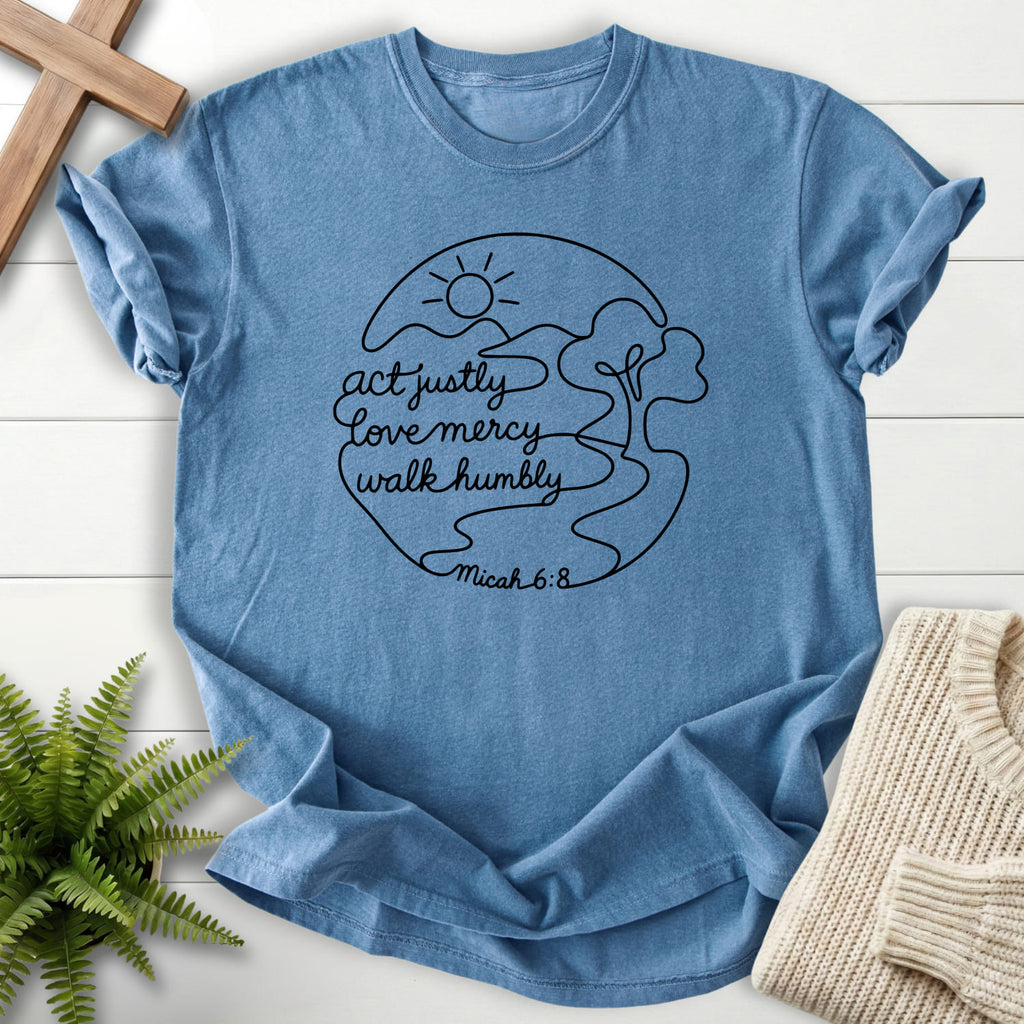 Flatlay of a Blue Jean Comfort Colors 1717 garment-dyed Christian tee with sunrise graphic with "Act Justly Micah 6 8 Dark T-Shirt".
