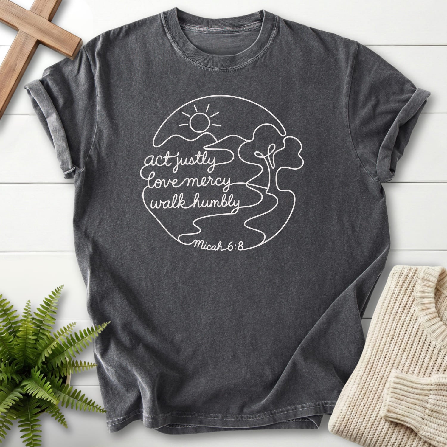 Flat lay of a Pepper Comfort Colors 1717 Christian t-shirt for women featuring sunrise graphic with "Act Justly Micah 6 8 Dark T-Shirt".