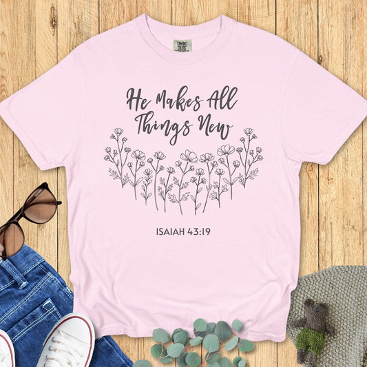 Comfort Colors 1717 Christian women t-shirt in blossom pink flat lay. Faith-based design shows hand-drawn flowers with scripture “He Makes All Things New – Isaiah 43:19