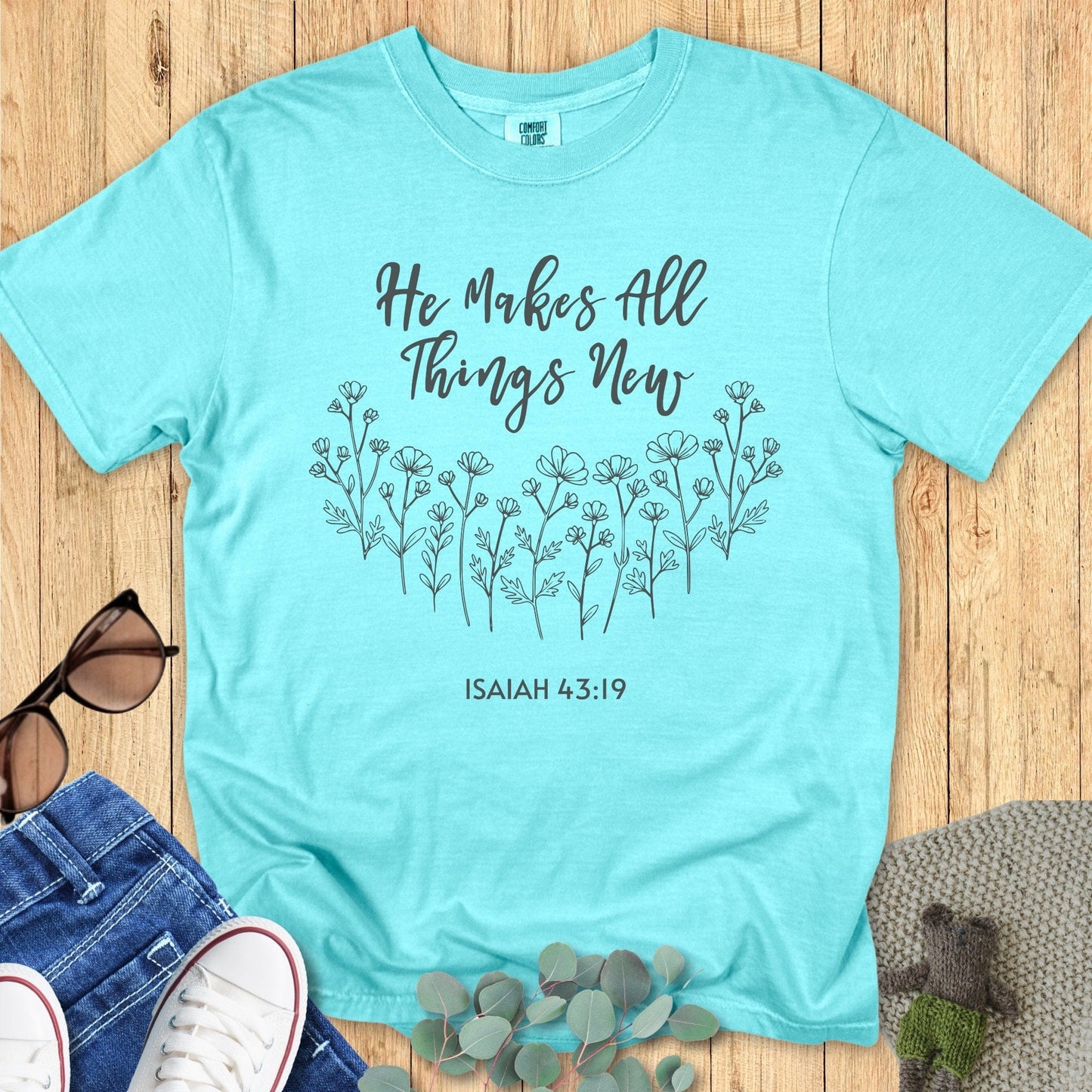 Comfort Colors 1717 Christian women t-shirt in chalky mint flat lay. Christian women’s design features floral line art and the verse “He Makes All Things New – Isaiah 43:19