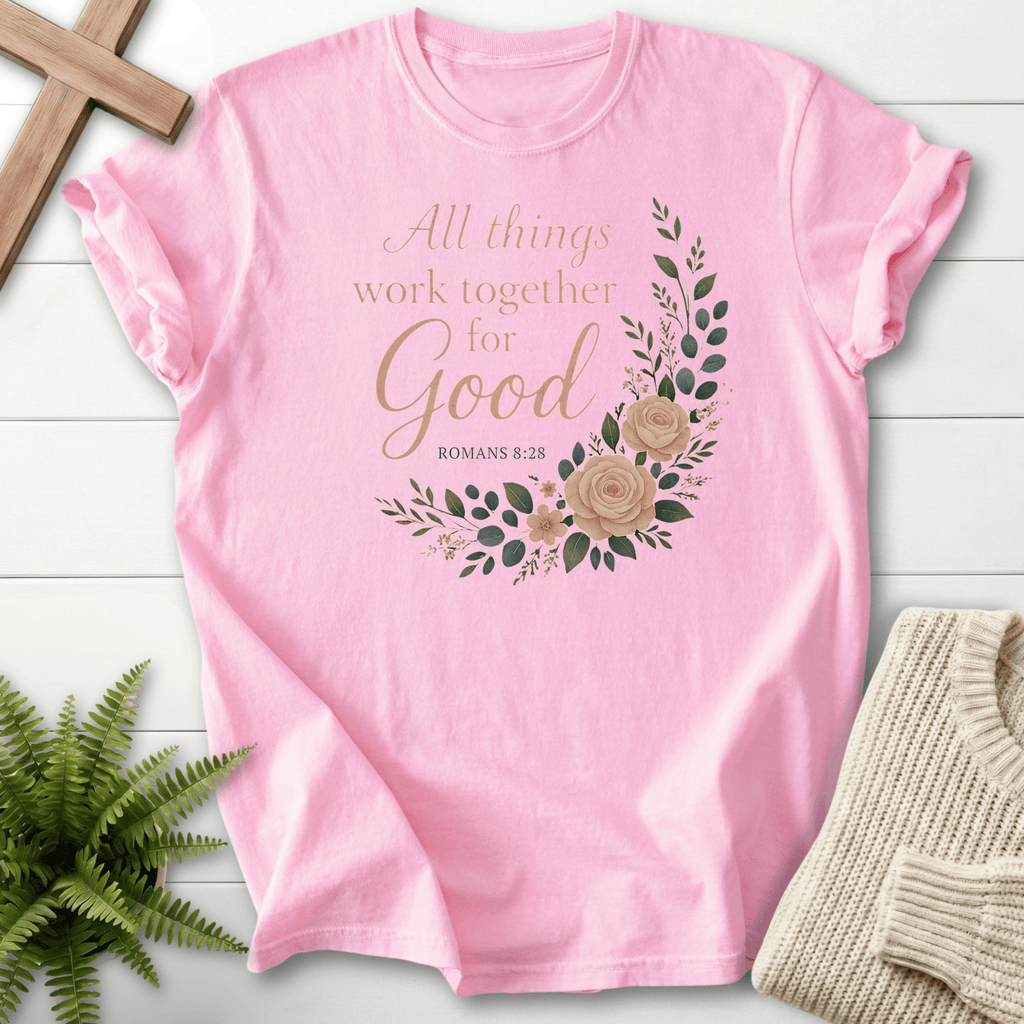Blossom pink Christian t-shirt for women with Romans 8:28 script and watercolor rose artwork, inspired by Romans 8:28.