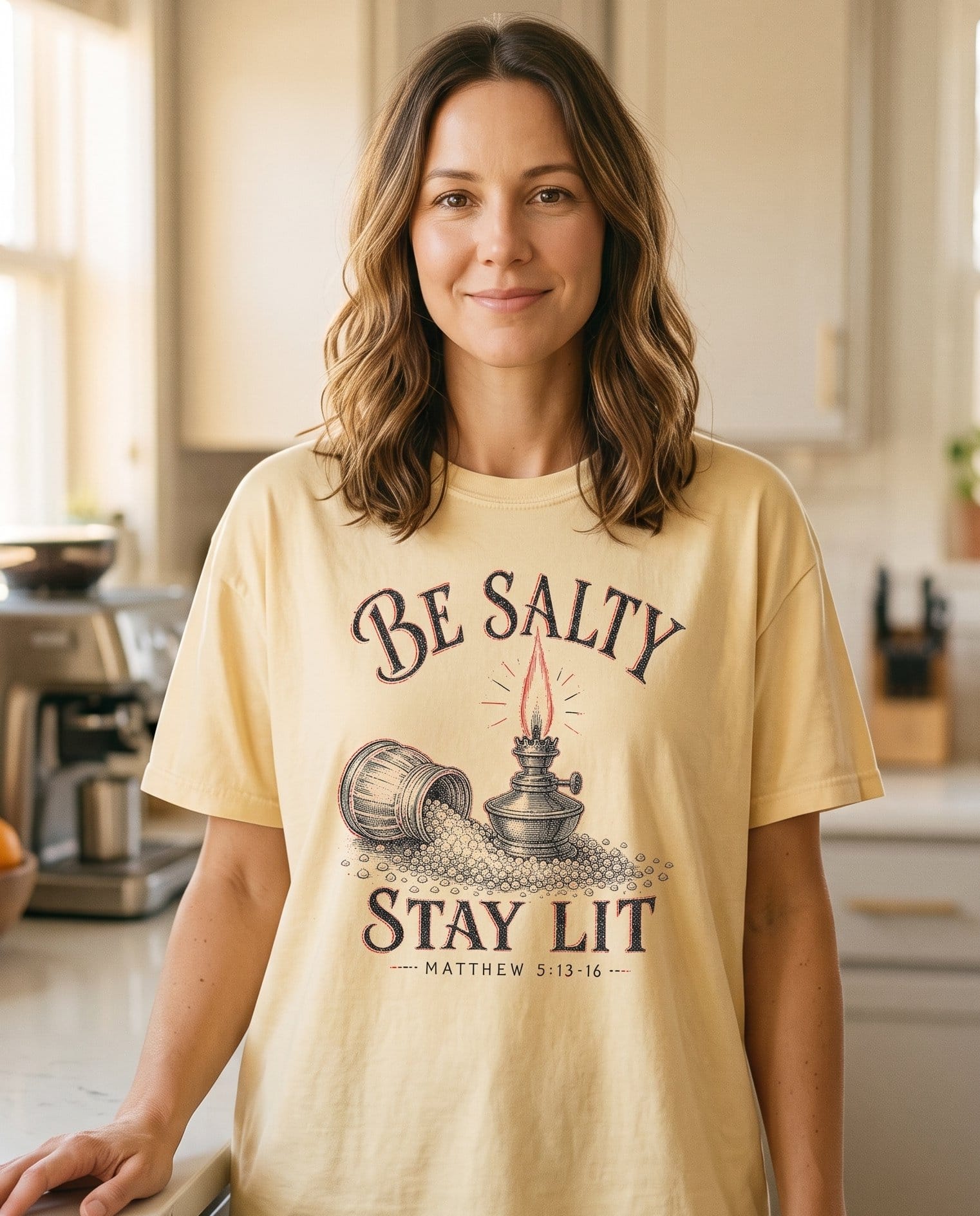 Be Salty Vintage Lamp Matt 5:13-16 – Banana women's Christian tee, lifestyle photo in morning kitchen setting – Vintage arched lettering BE SALTY over an engraved-style oil lamp with – Matthew 5:13-16 – She Wears Faith