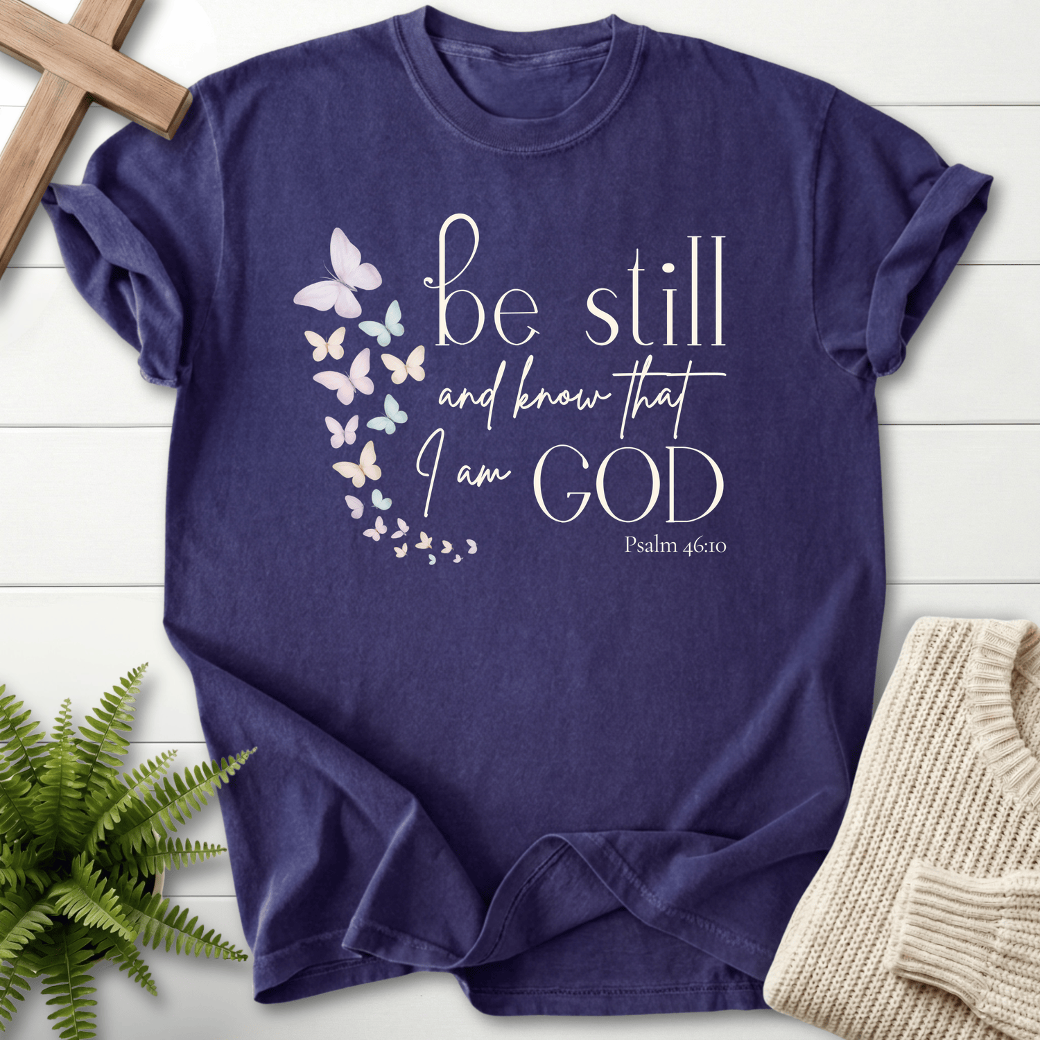 Grape Christian t-shirt for women with a watercolor butterfly cascade and 'Be Still and Know', inspired by Psalm 46:10.