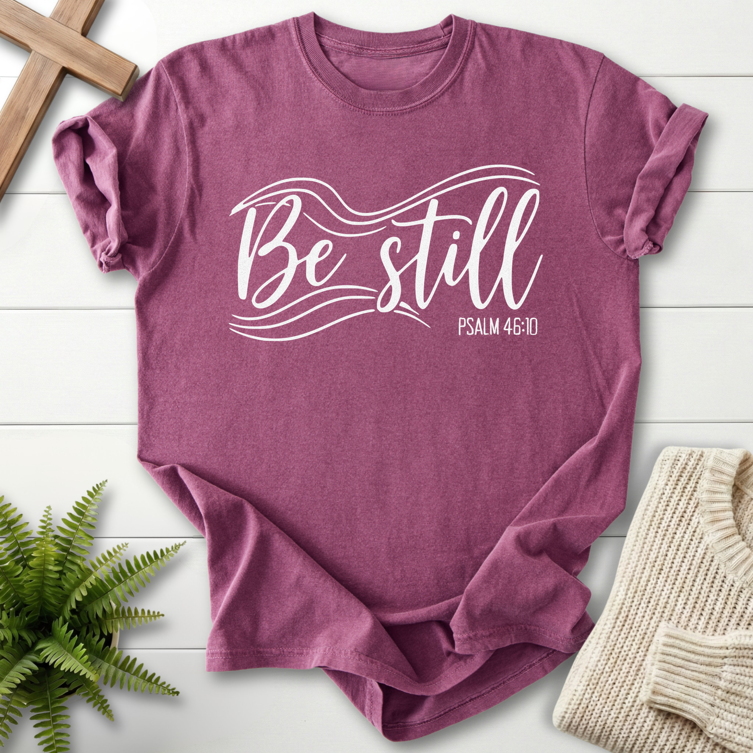 Berry Christian t-shirt for women with white calligraphy script and wave line design, inspired by Psalm 46:10.
