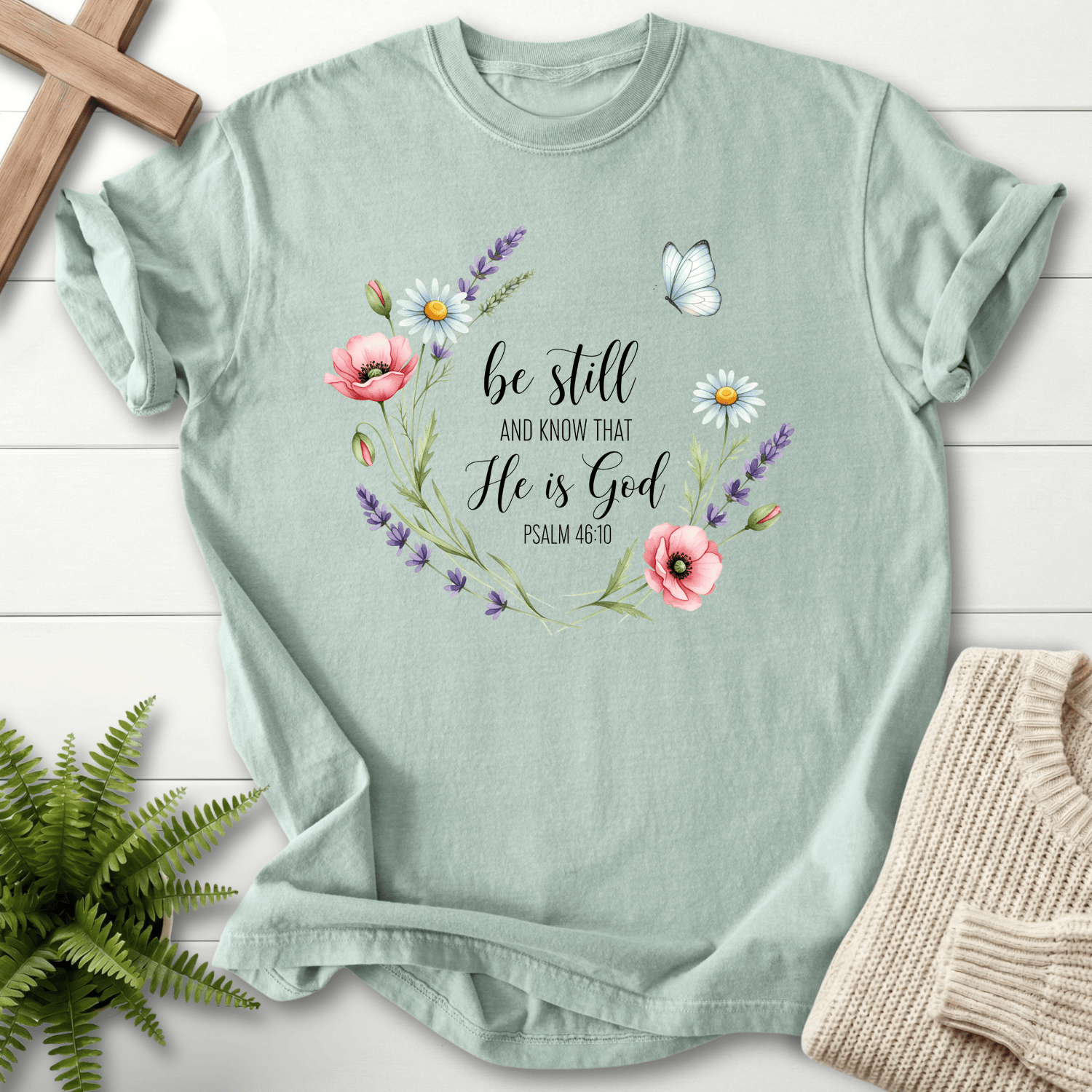 Bay Christian t-shirt for women with 'Be Still and Know That He Is God' and a floral wreath design, inspired by Psalm 46:10.