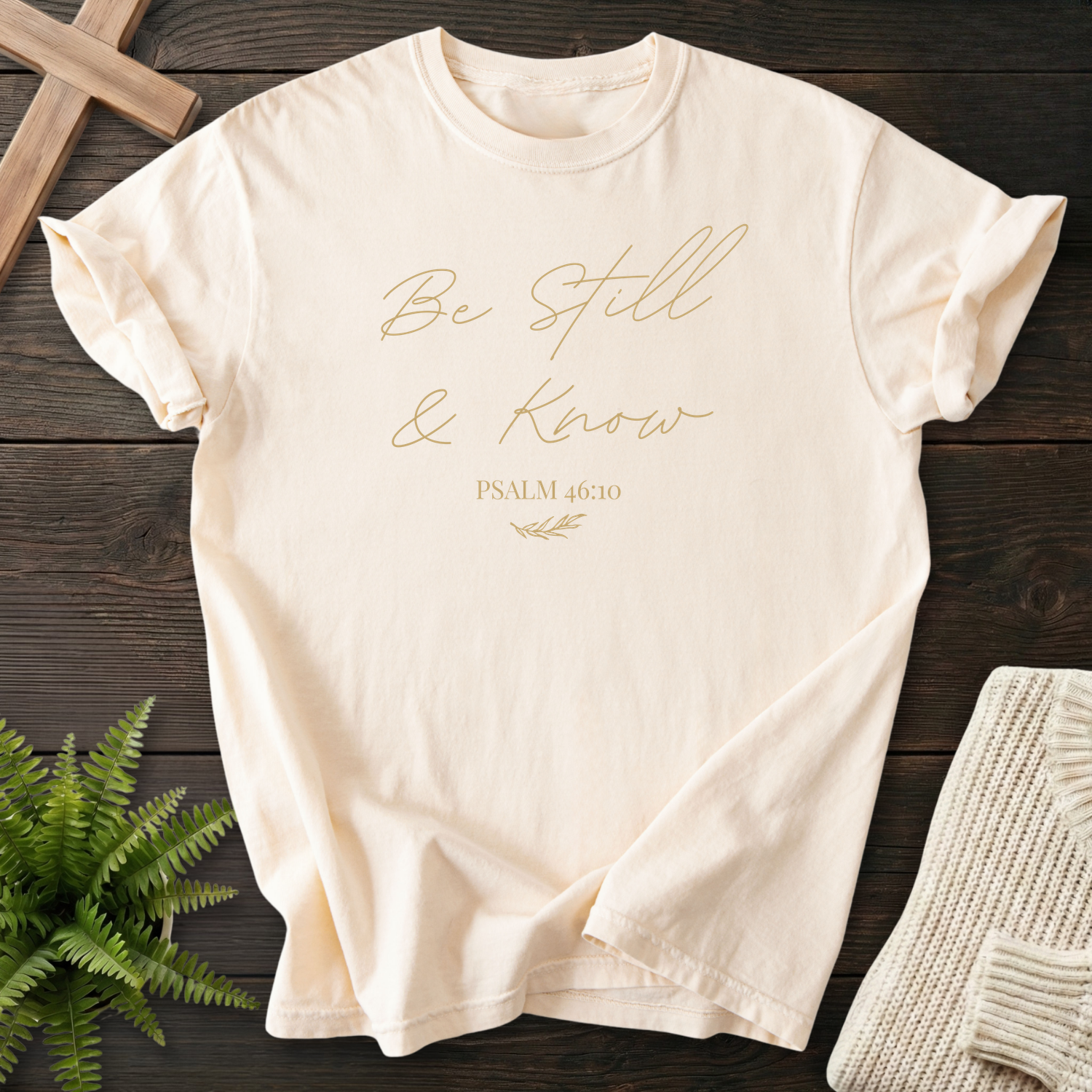 Ivory Christian t-shirt for women with minimalist gold 'Be Still and Know' script design by She Wears Faith
