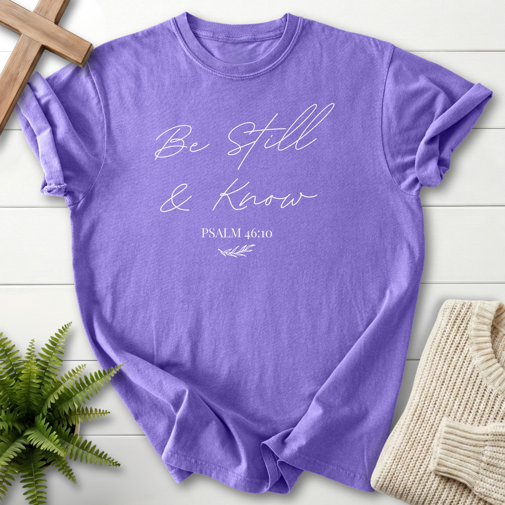 Violet garment-dyed Christian t-shirt for women with elegant gold 'Be Still and Know' Psalm 46:10 script