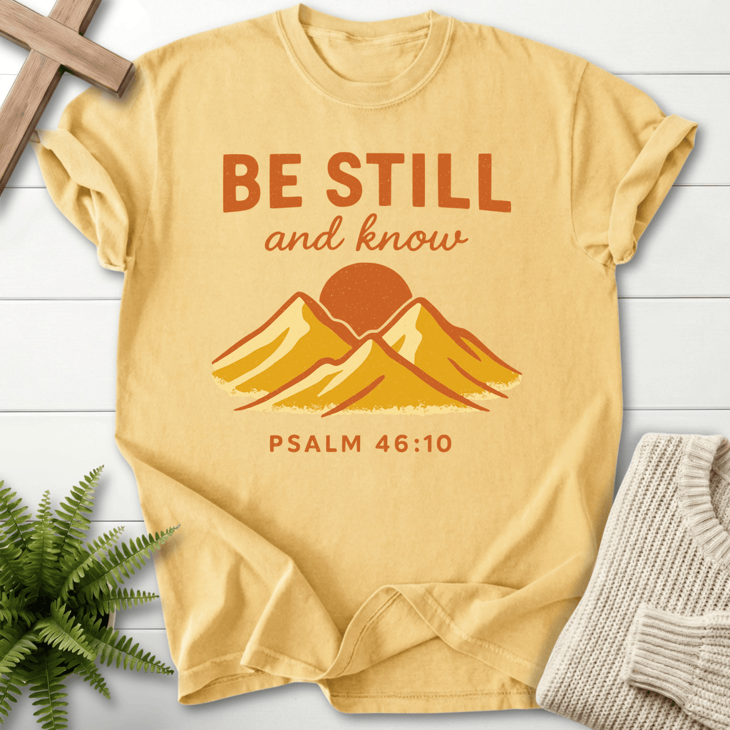 Butter yellow Christian t-shirt for women with retro mountain sunrise artwork and 'Be Still and Know', inspired by Psalm 46:10.
