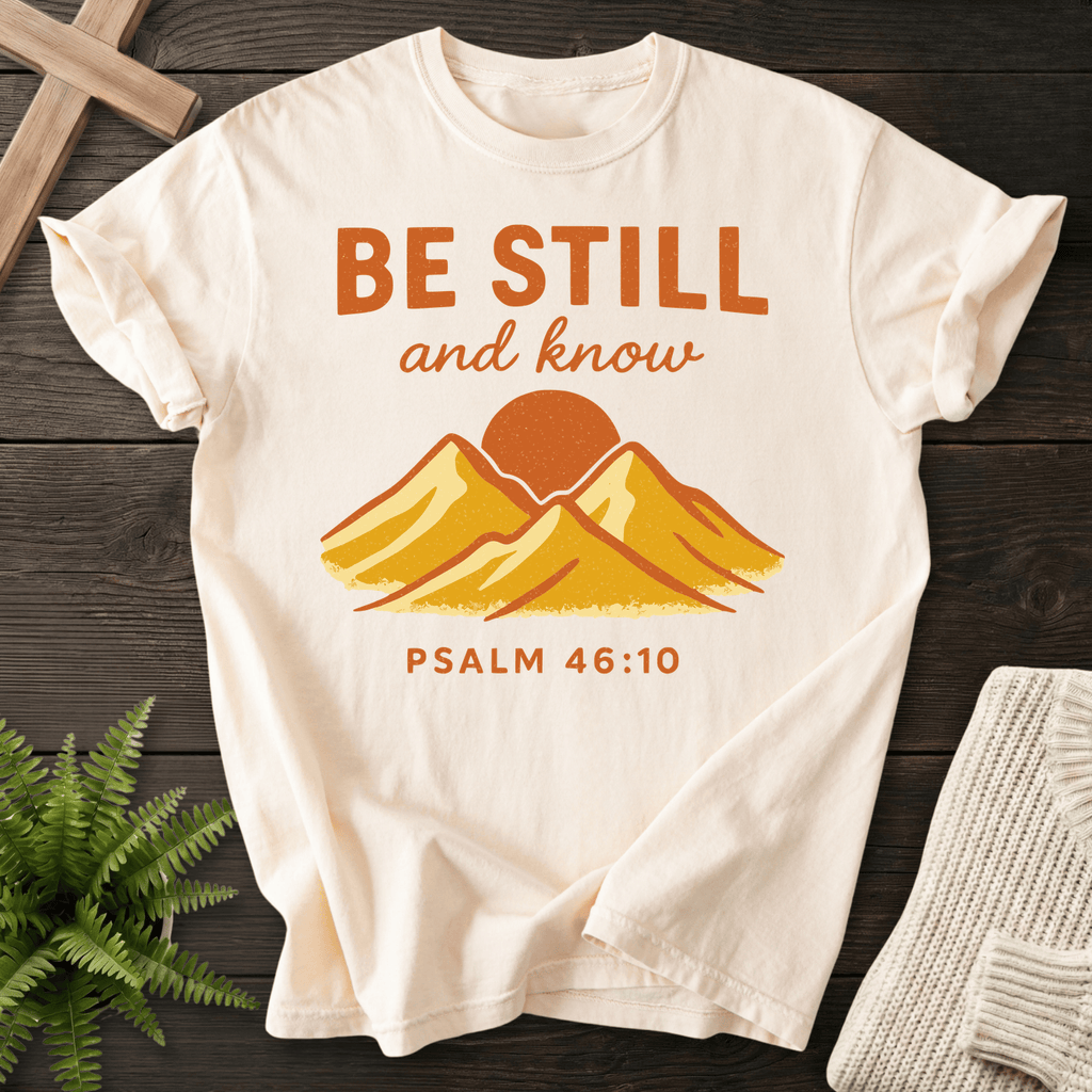 Ivory Christian t-shirt for women with a retro mountain sunrise illustration and 'Be Still and Know', inspired by Psalm 46:10.