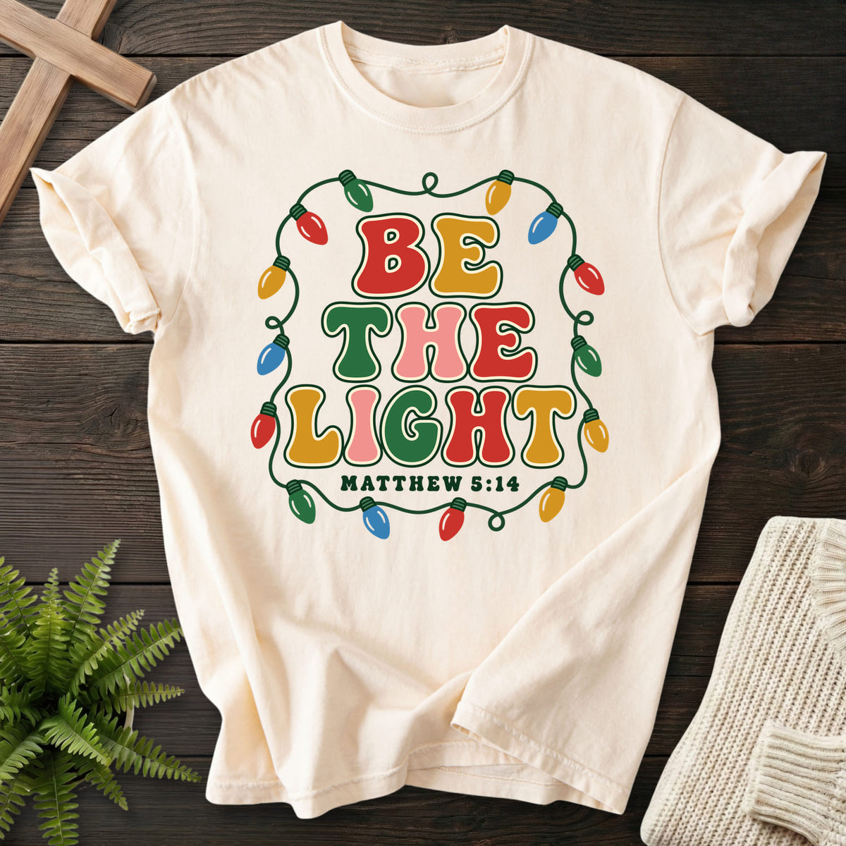 Ivory Be the Light Christmas Lights T-shirt flat lay mockup, Matthew 5:14 Christian apparel for women