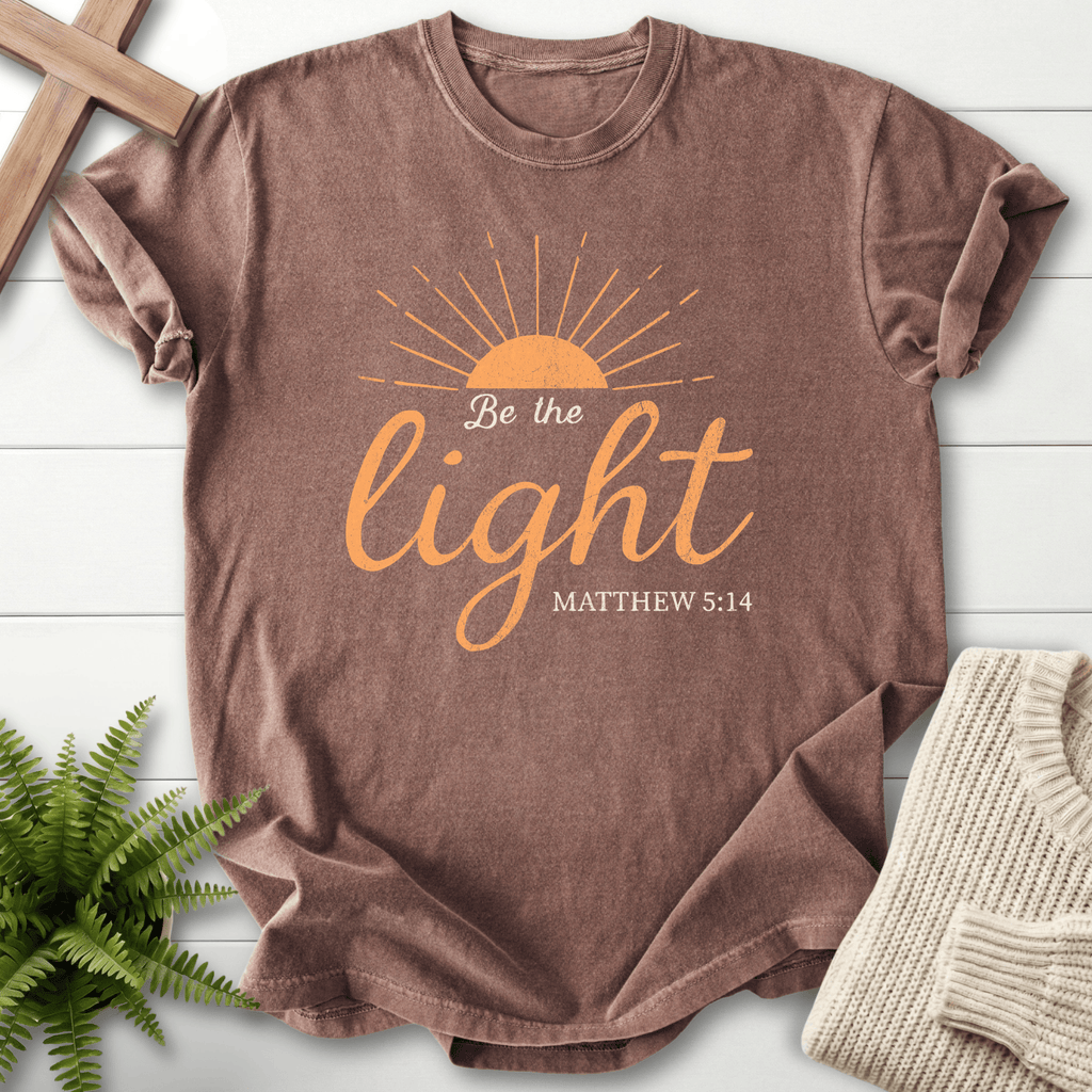Espresso Christian t-shirt for women with a rising sun and warm orange script, 'Be the Light', inspired by Matthew 5:14.