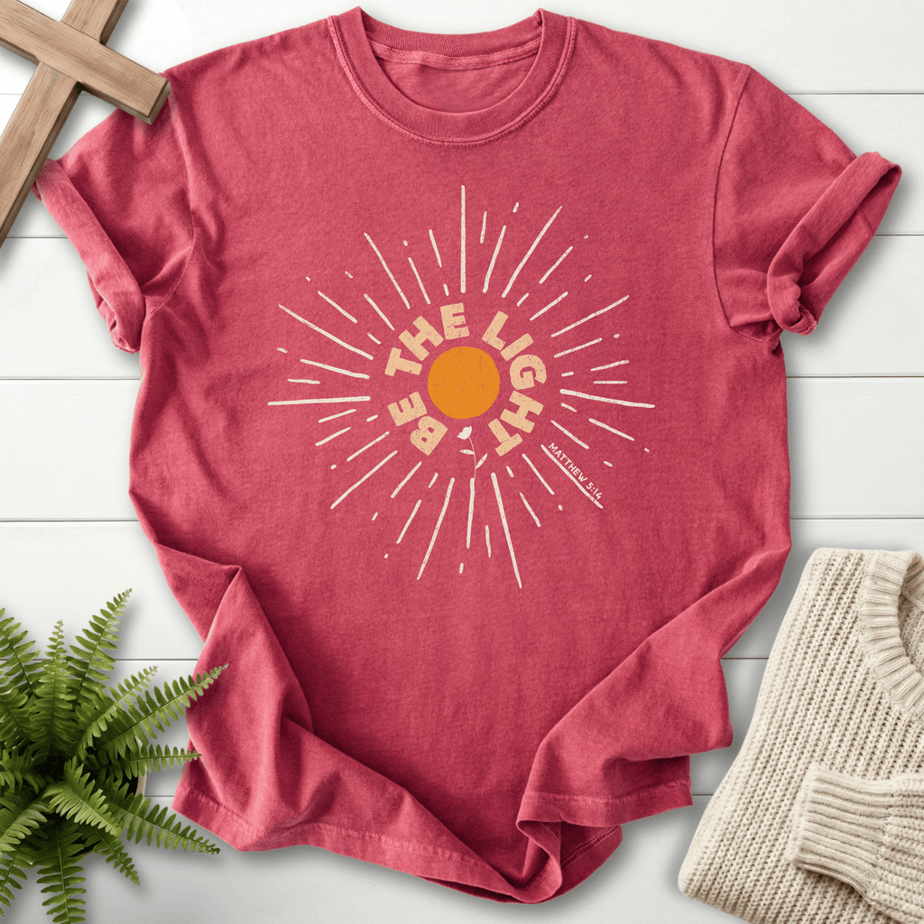 Crimson Christian t-shirt for women with a retro sun ray circular graphic and 'Be the Light', inspired by Matthew 5:14.