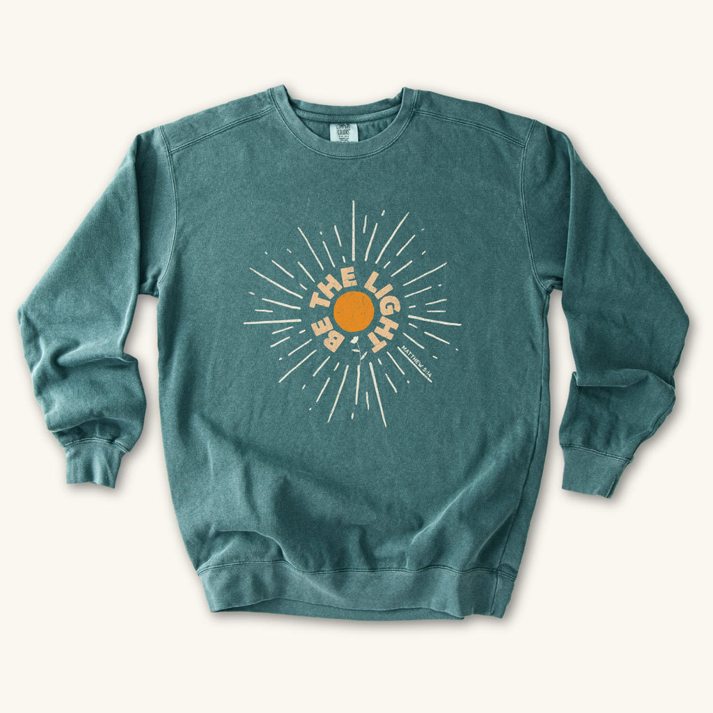 Blue Spruce Be The Light Sunburst sweatshirt flat lay mockup, Matthew 5:14 Christian apparel for women