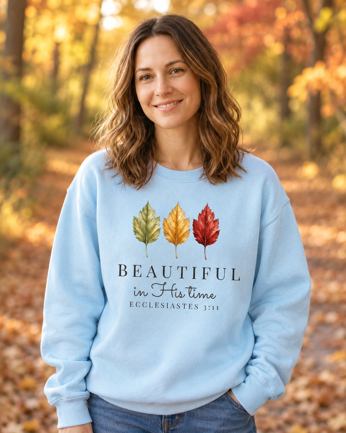Beautiful in His Time – Chambray women's Christian sweatshirt, lifestyle photo in cozy autumn harvest setting – Three autumn leaves above BEAUTIFUL in His time – She Wears Faith