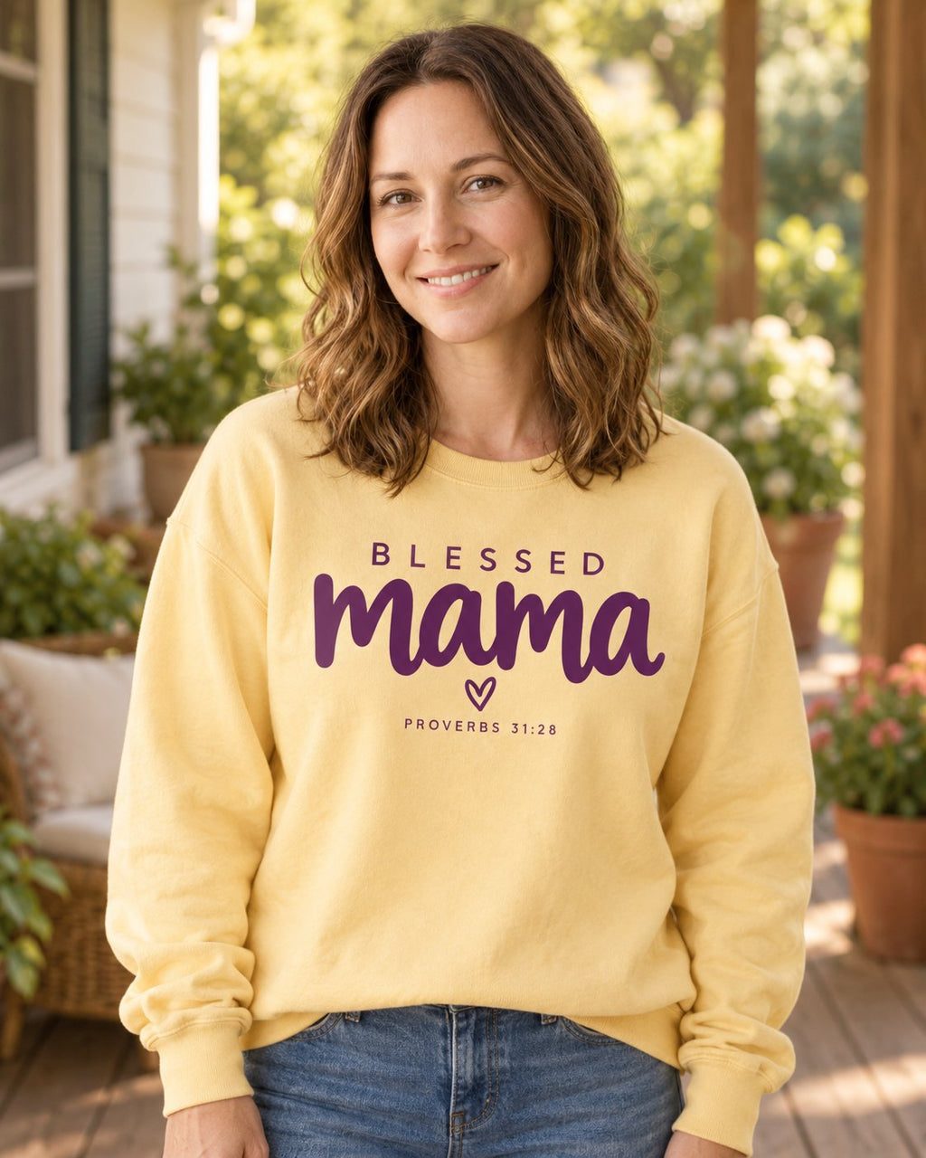 Blessed Mama Minimalist Heart – Butter women's Christian sweatshirt, lifestyle photo in sunny porch – Minimalist BLESSED mama script lettering with a small heart – She Wears Faith