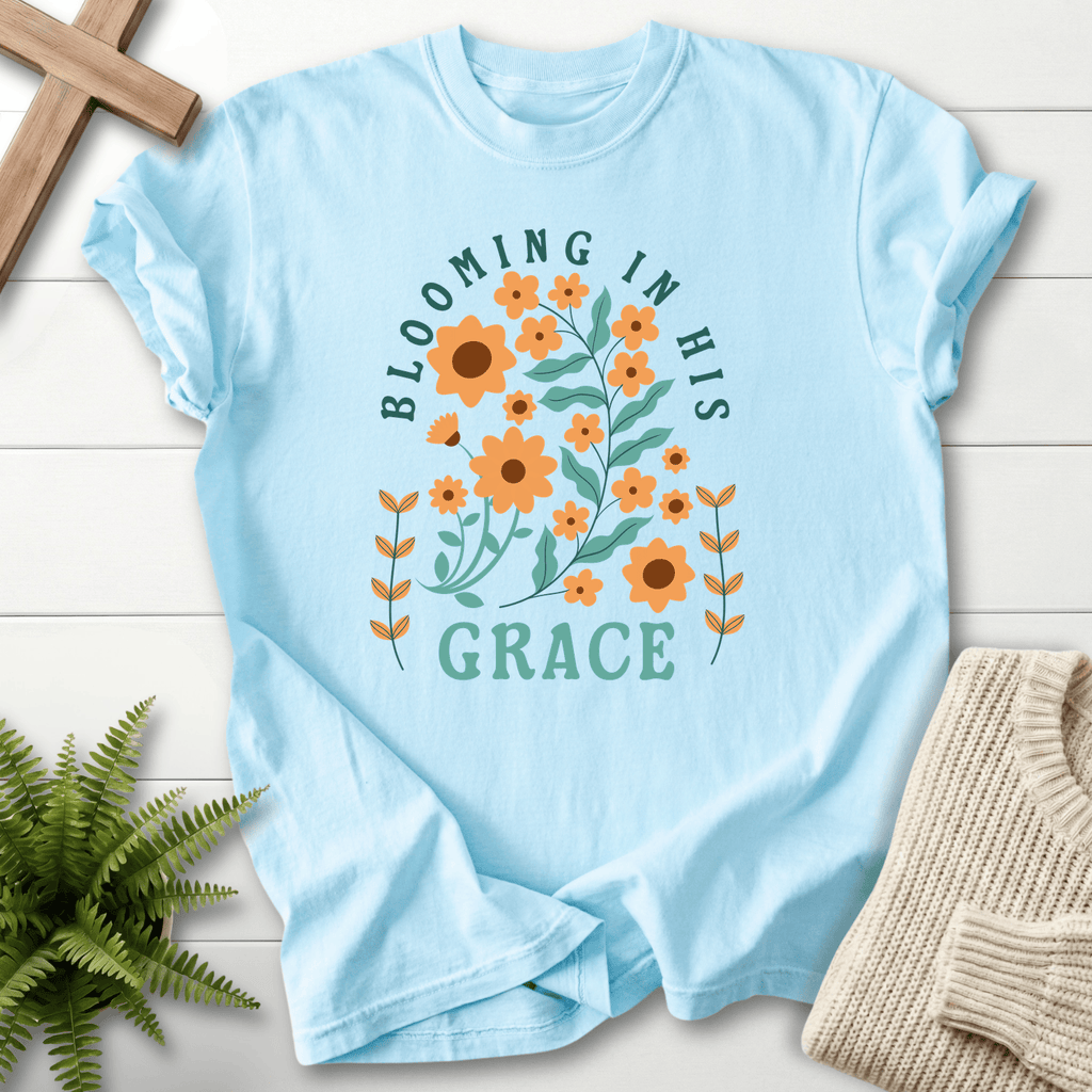 Chambray Christian t-shirt for women with a retro sunflower design and teal block lettering, She Wears Faith.