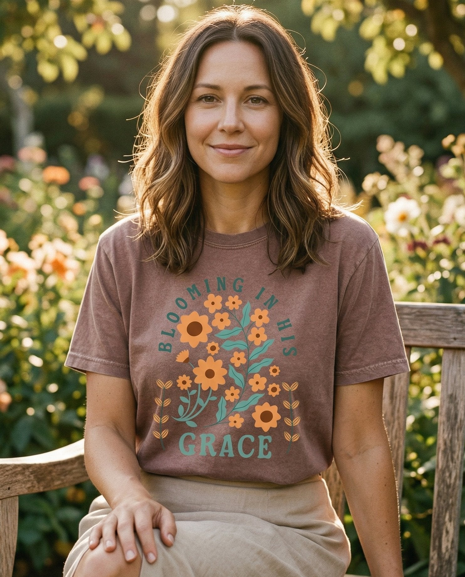 Blooming in His Grace – Espresso women's Christian tee, lifestyle photo in outdoor garden – Retro botanical illustration with orange sunflowers and teal leaves ar – She Wears Faith