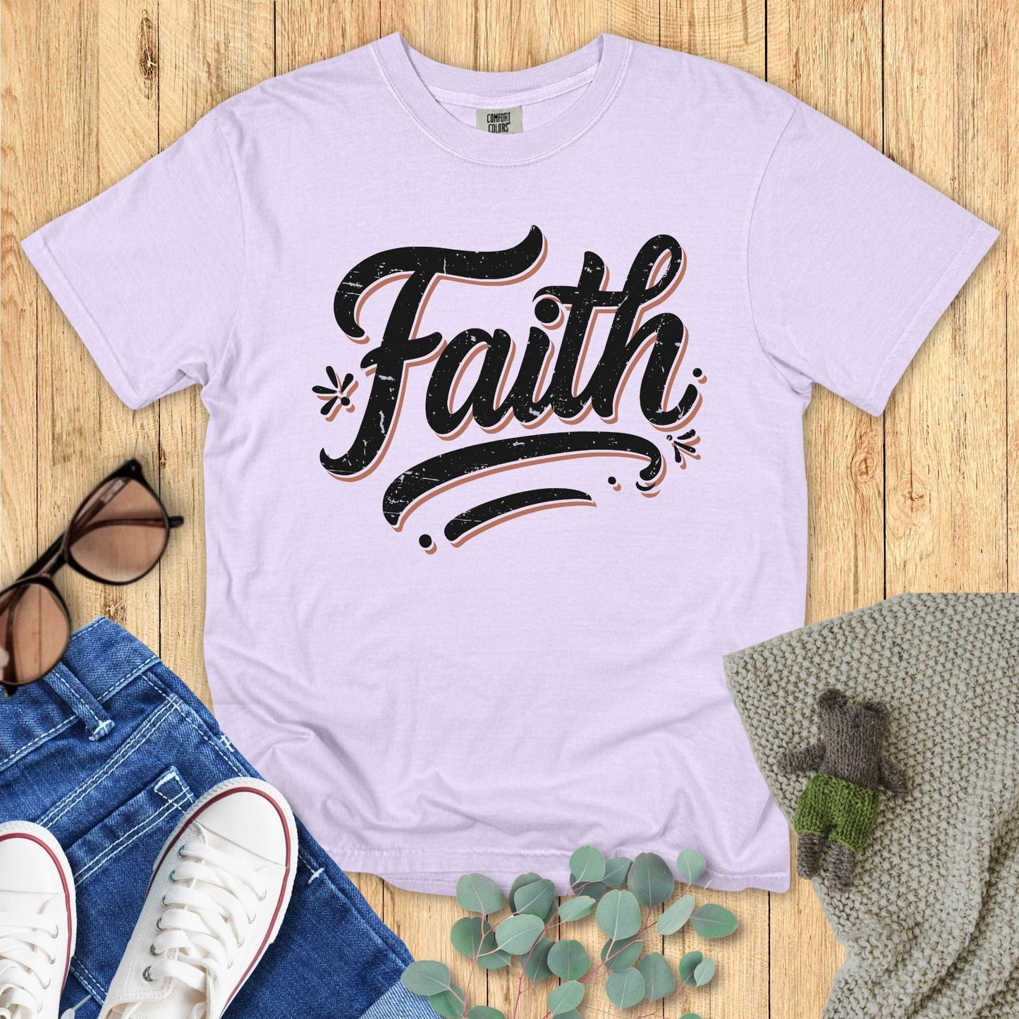 Comfort Colors 1717 orchid “Faith” t-shirt with distressed black script typography, styled with jeans and cozy details. A soft and feminine design from women’s scripture tees, thoughtful as a Christian mom gift idea.
