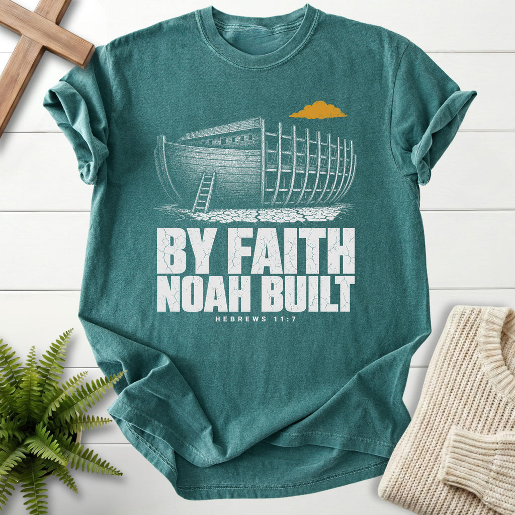 Flatlay of a Blue Spruce Comfort Colors 1717 garment-dyed Christian tee with "By Faith Noah Built Hebrews 11 7 T-Shirt" Hebrews 11:7 From Printify.