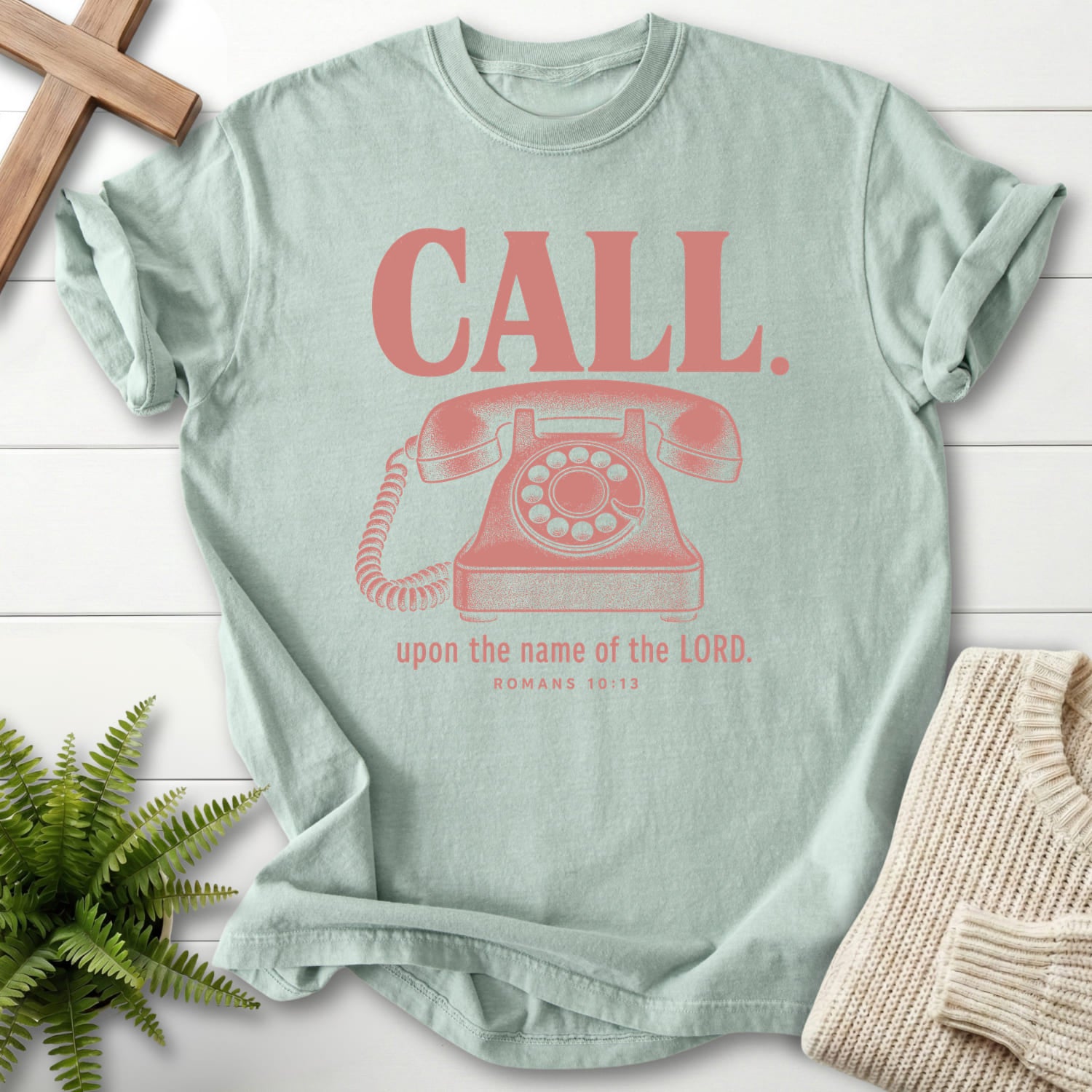 Flat lay of a Bay women's Christian tee featuring "Call Upon the Name of the Lord T-Shirt" Romans 10:13.