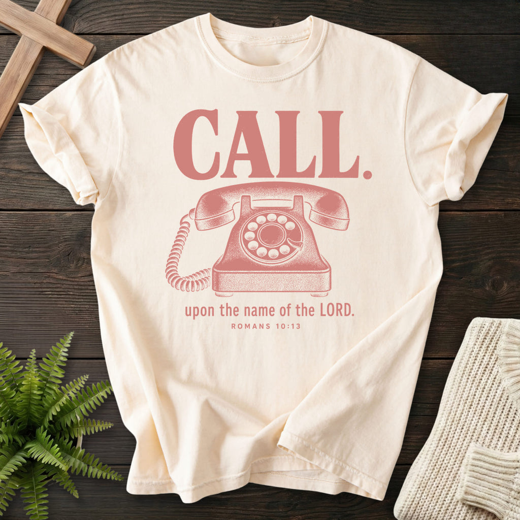 Flat lay of an Ivory Comfort Colors 1717 Christian t-shirt for women featuring "Call Upon the Name of the Lord T-Shirt" Romans 10:13 From Printify.
