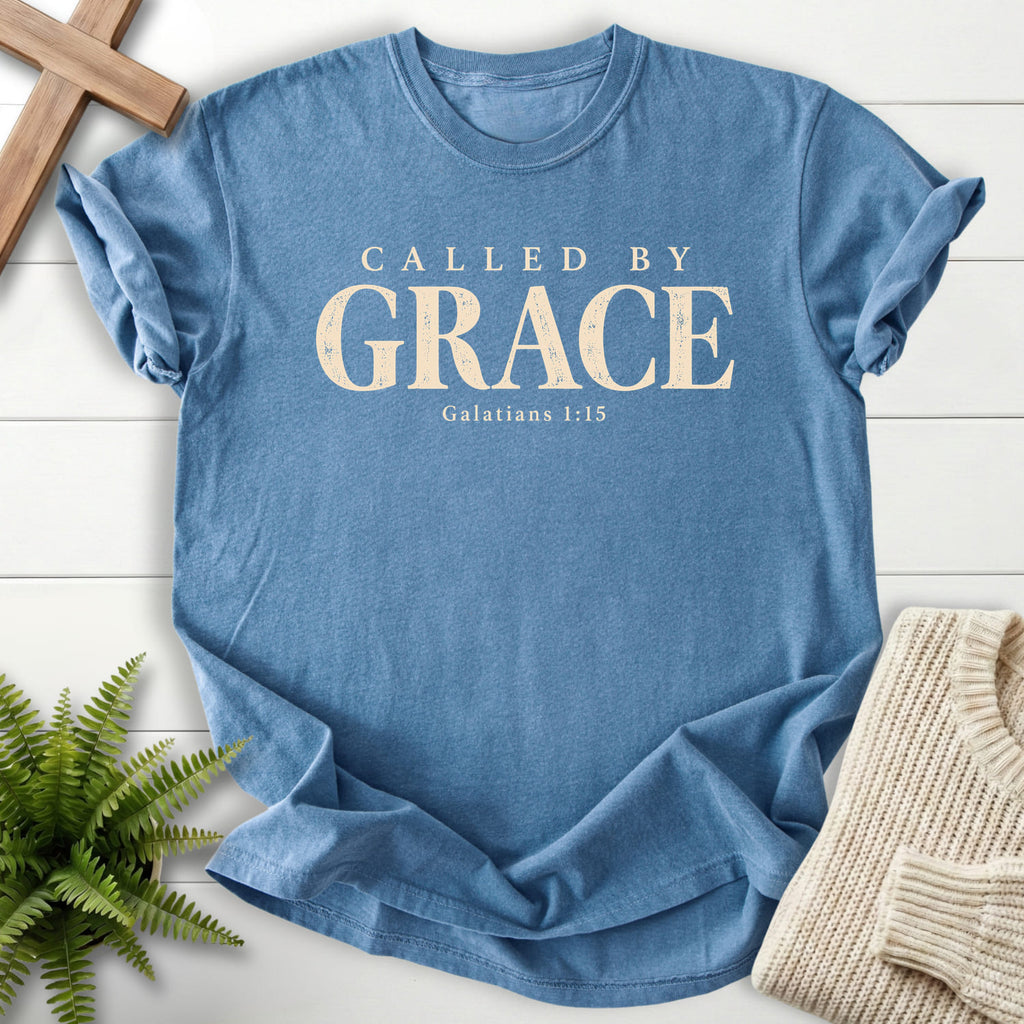 Flat lay of a Blue Jean Christian graphic tee featuring "Called by Grace T-Shirt" Galatians 1:15.