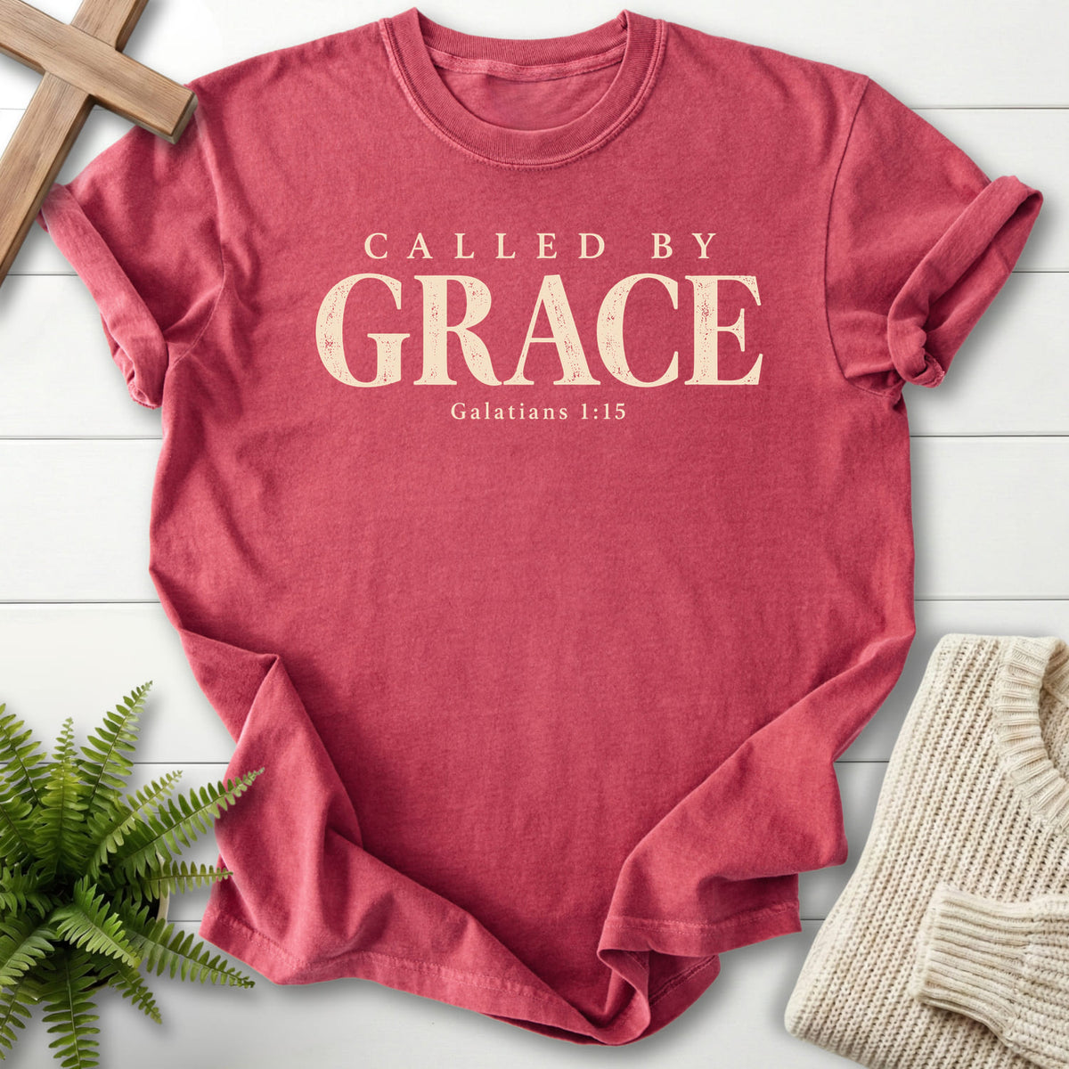 Flatlay of a Crimson Comfort Colors 1717 women's Christian tee with "Called by Grace T-Shirt" Galatians 1:15.