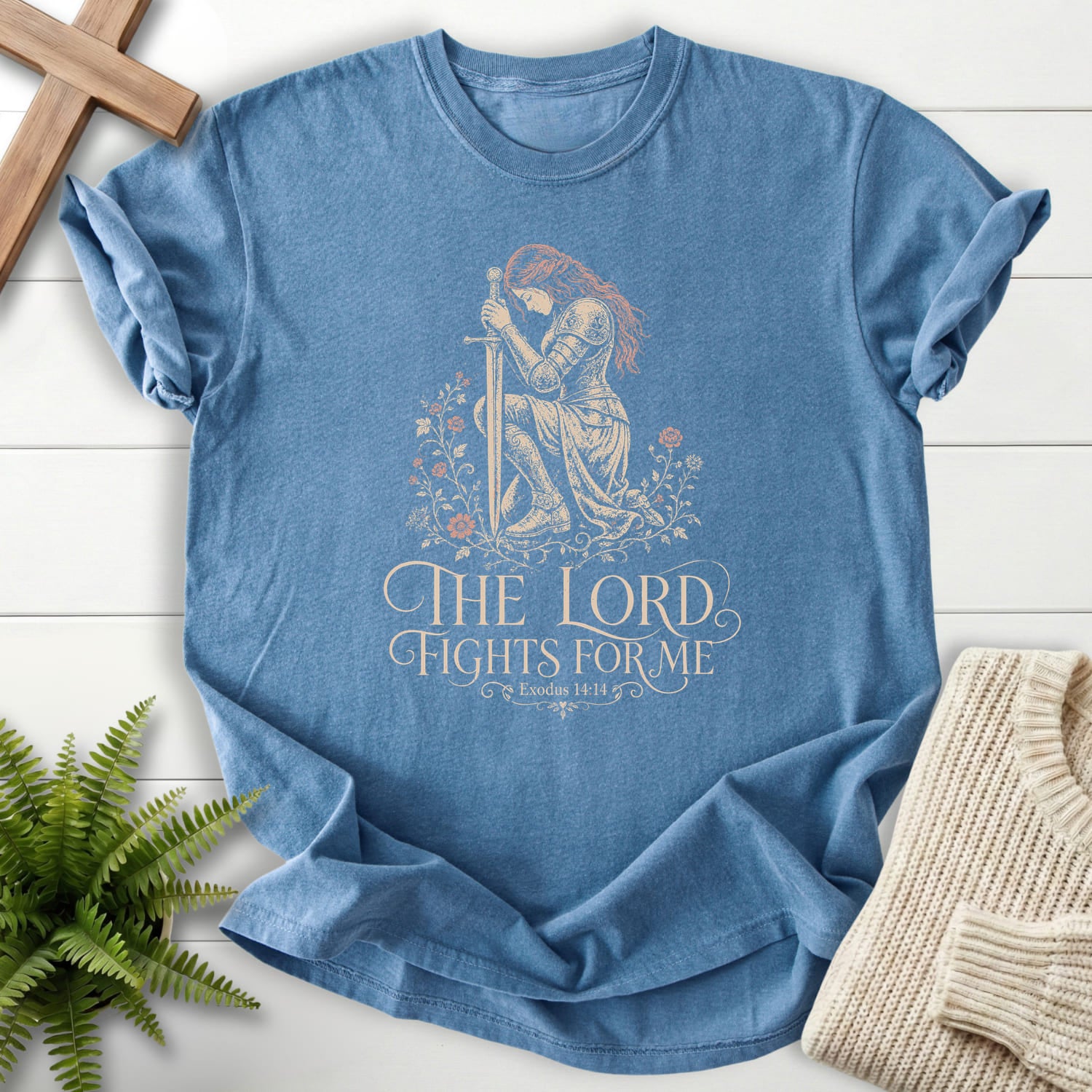 Flatlay of a Blue Jean Bible verse tee with floral line art with "The LORD Fights For Me T-Shirt" Exodus 14:14.