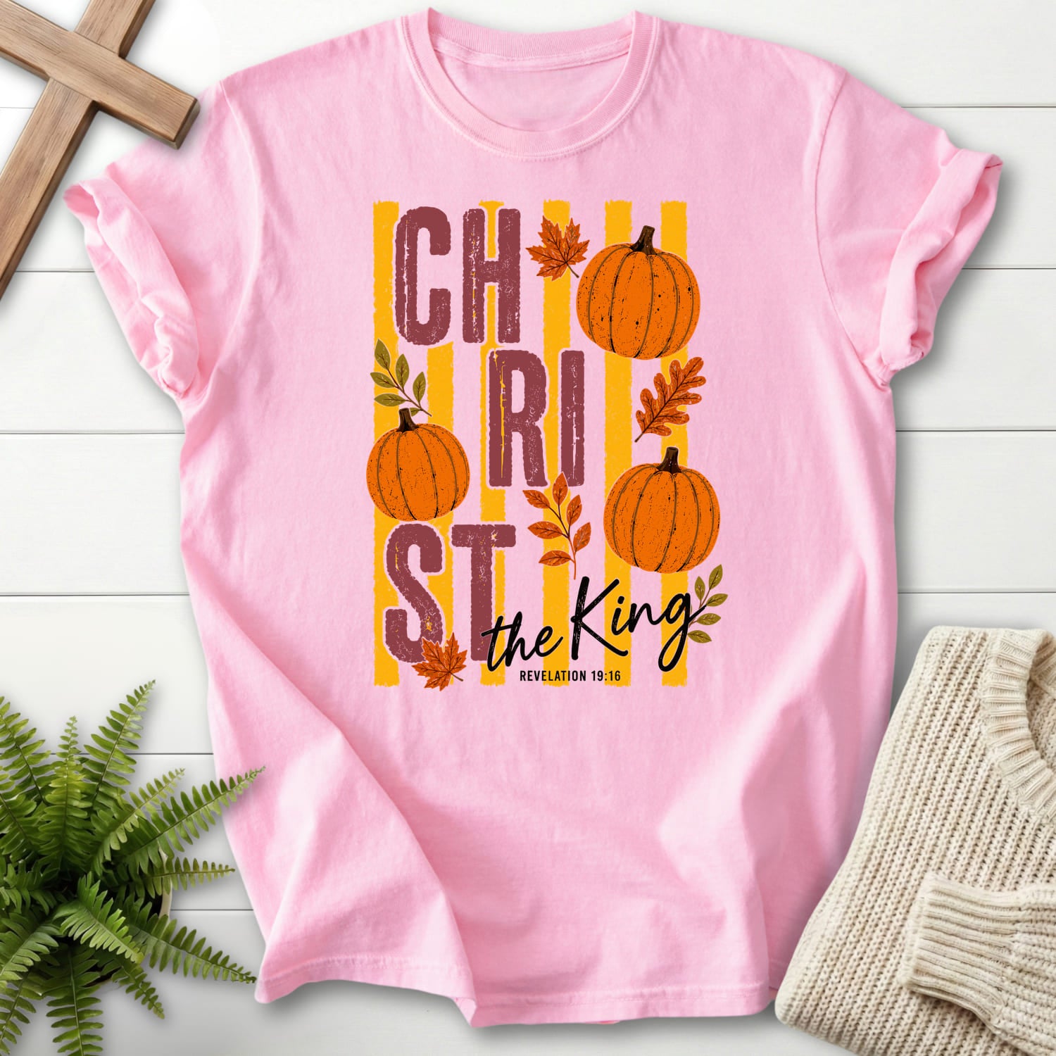 Flatlay of a Blossom Comfort Colors 1717 faith-inspired shirt with script typography with "Christ The King Fall T-Shirt" Revelation 1:16.