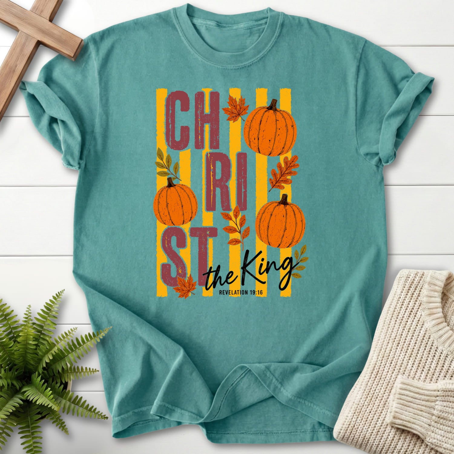 Flat lay of a Chalky Mint Christian t-shirt for women featuring script typography with "Christ The King Fall T-Shirt" Revelation 1:16 From Printify.