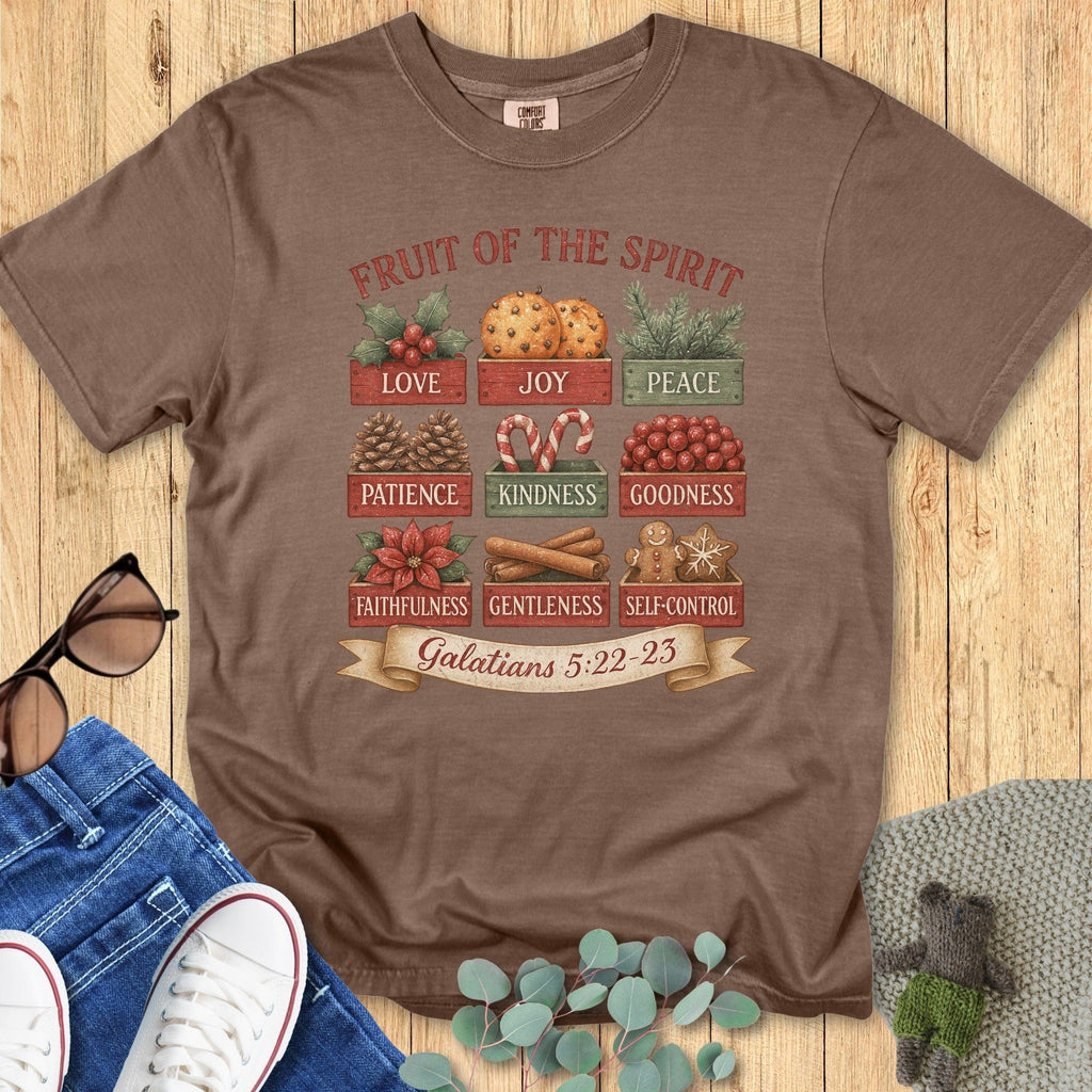Flatlay of a Comfort Colors 1717 espresso “Fruit of the Spirit” t-shirt featuring nine illustrated traits from Galatians 5:22–23 in warm Christmas tones. A rustic women’s scripture tee — faith-based apparel for women and modern Christian shirt, meaningful Christian mom gift idea.