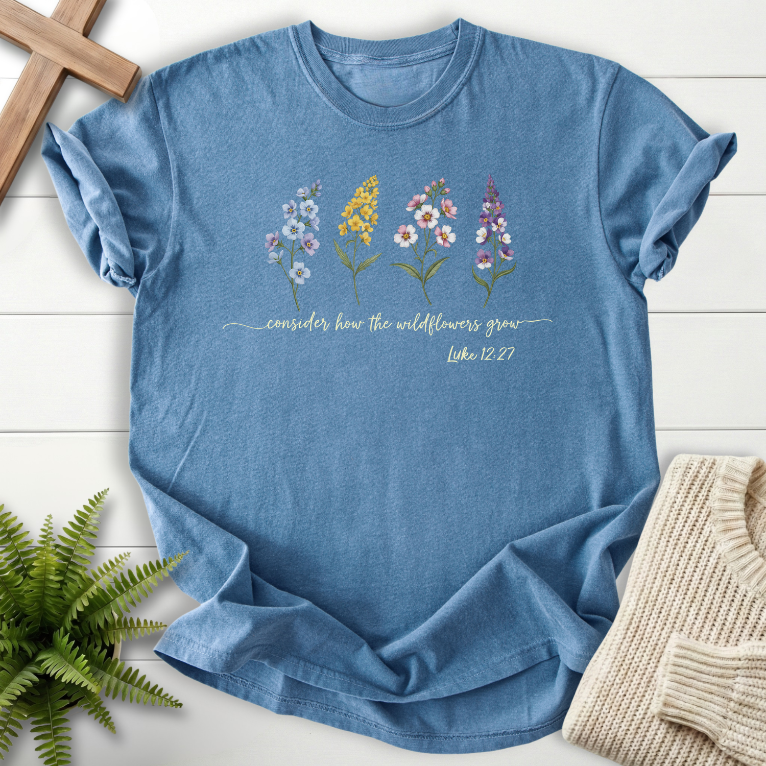 Blue Jean Christian t-shirt for women with a colorful wildflower illustration, inspired by Luke 12:27.