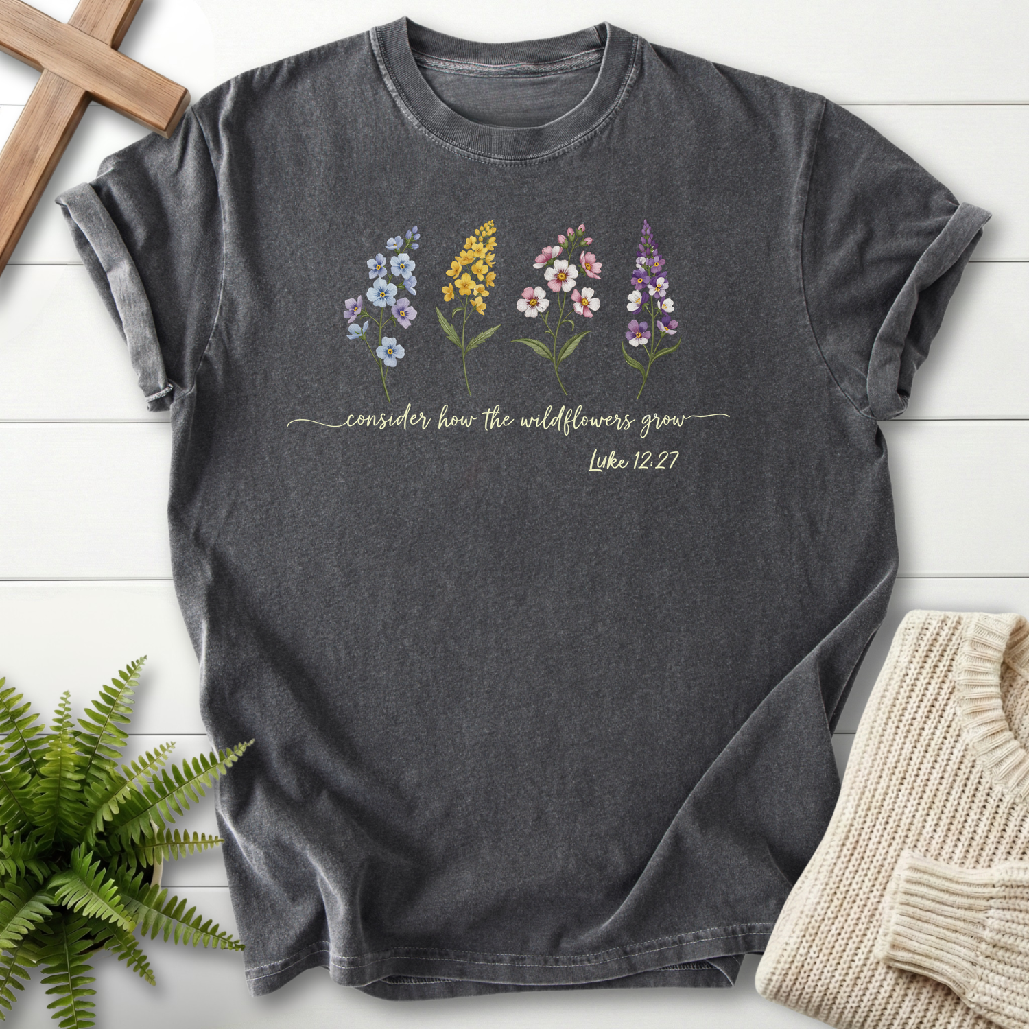 Pepper Christian t-shirt for women with four illustrated wildflowers and flowing script, inspired by Luke 12:27.