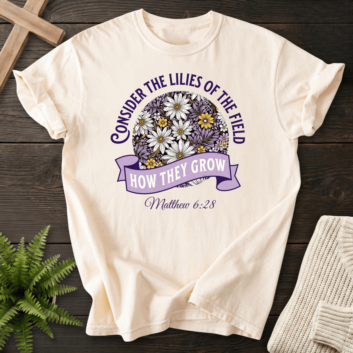 Ivory Christian t-shirt for women with a purple floral sphere graphic, inspired by Matthew 6:28.