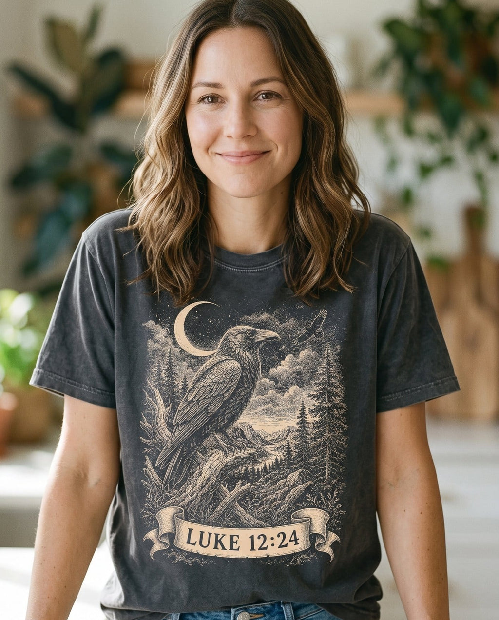 Consider the Ravens – Pepper women's Christian tee, lifestyle photo in morning kitchen setting – Dramatic engraved-style raven perched beneath a crescent moon – Luke 12:24 – She Wears Faith