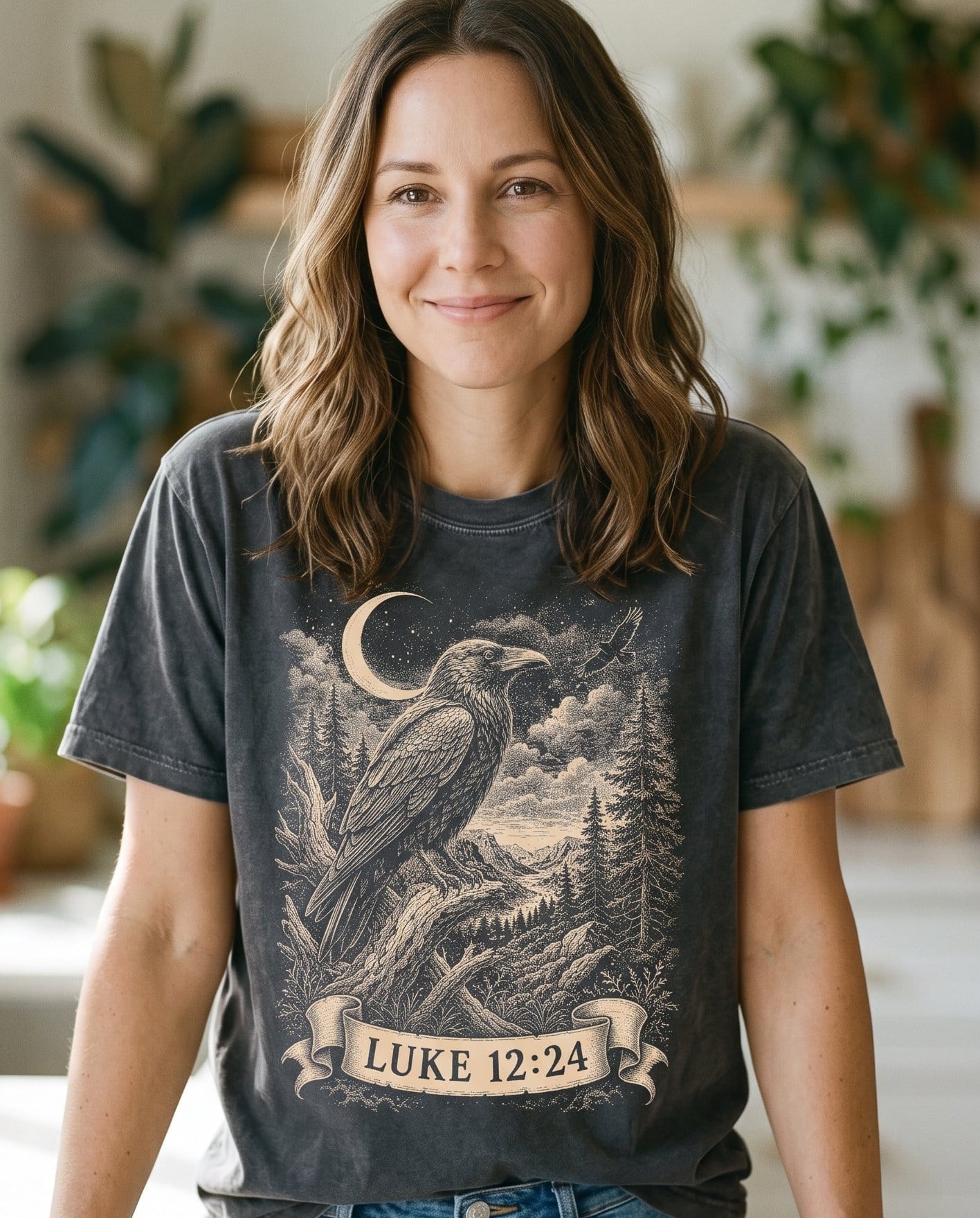 Consider the Ravens – Pepper women's Christian tee, lifestyle photo in morning kitchen setting – Dramatic engraved-style raven perched beneath a crescent moon – Luke 12:24 – She Wears Faith