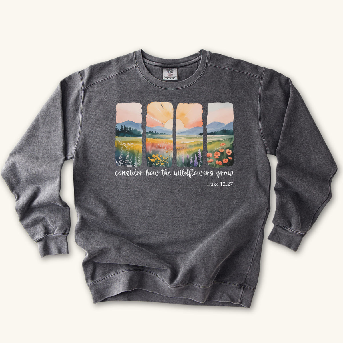 Pepper Christian sweatshirt with four painted panels of sunrise over hills and a wildflower meadow, reading consider how the wildflowers grow, Luke 12:27
