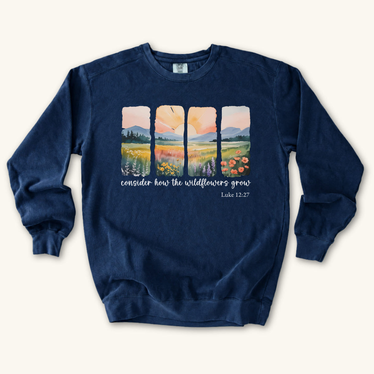 True Navy Christian sweatshirt with four painted panels of sunrise over hills and a wildflower meadow, reading consider how the wildflowers grow, Luke 12:27