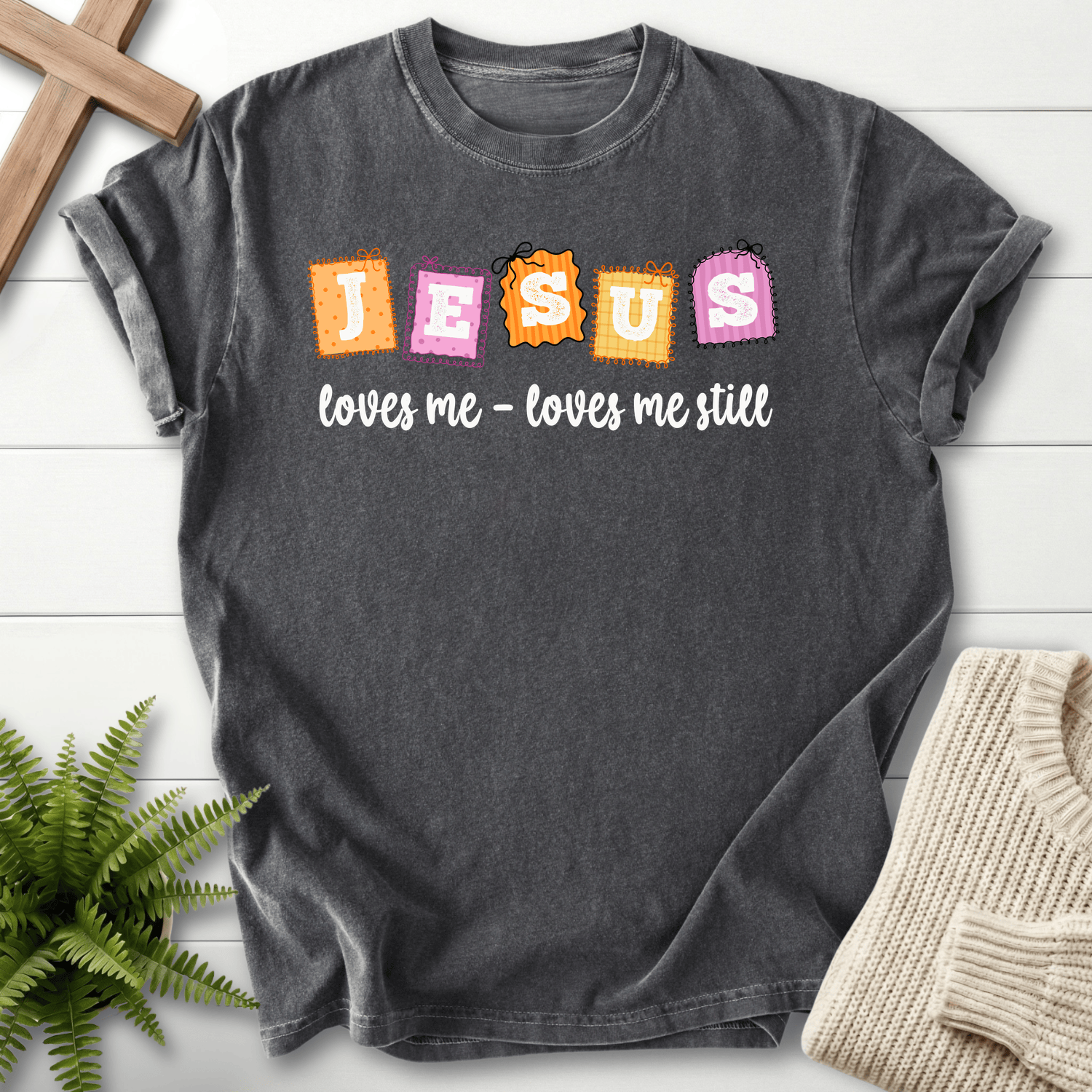 Pepper women's Christian t-shirt with a fun "Jesus loves me still" patchwork graphic
