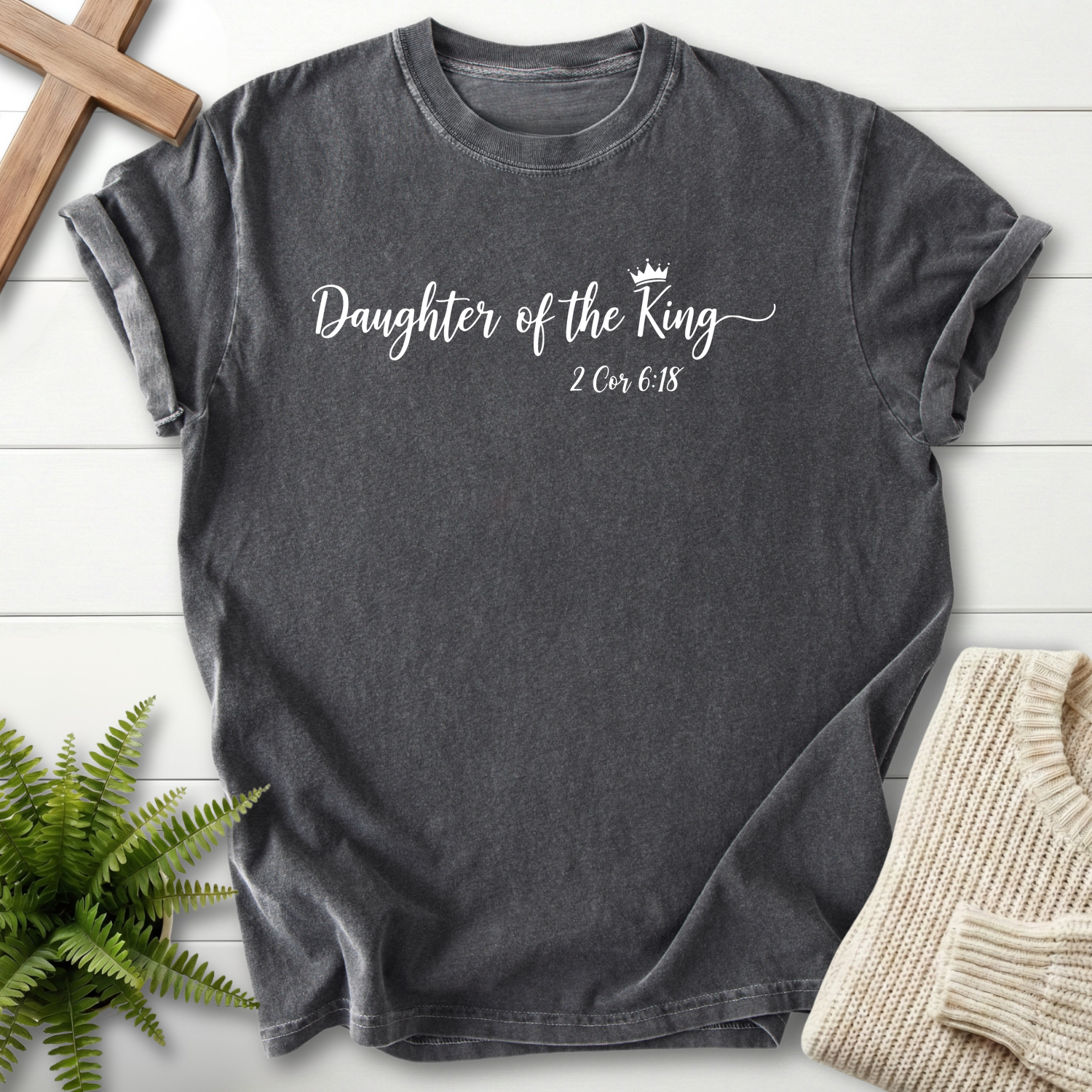 Pepper women's faith t-shirt with a crown icon and graceful cursive 'Daughter of the King' text, inspired by 2 Corinthians 6:18.