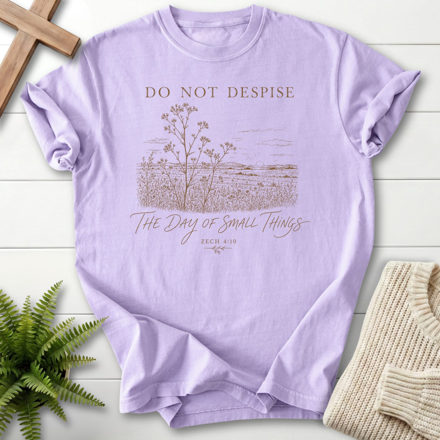 Flat lay of an Orchid women's Christian tee featuring floral line art with "Day of Small Things T-Shirt" Zechariah 4:10.