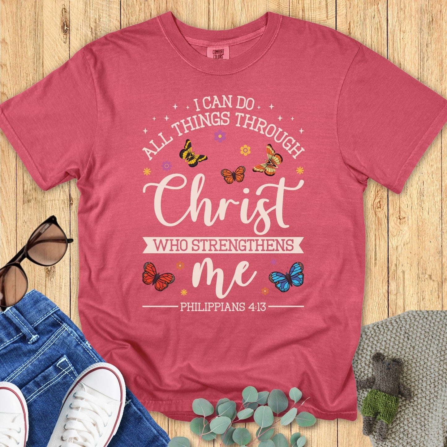 Comfort Colors 1717 crimson “I Can Do All Things Through Christ Who Strengthens Me – Philippians 4:13” t-shirt with cheerful butterflies and stars. A bold modern Christian shirt and perfect Christian mom gift idea to inspire daily faith.