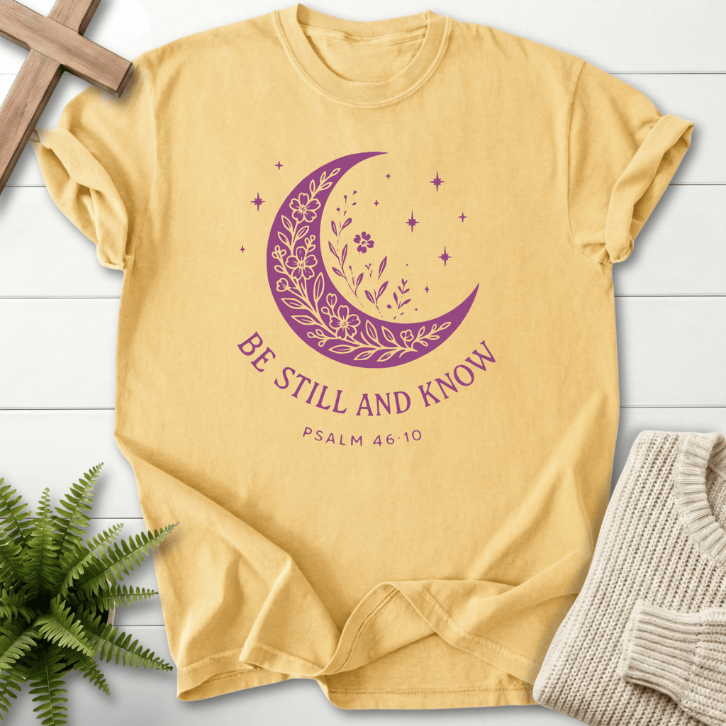 Butter yellow Scripture shirt for women with a purple crescent moon, wildflowers, and 'Be Still and Know', by She Wears Faith.