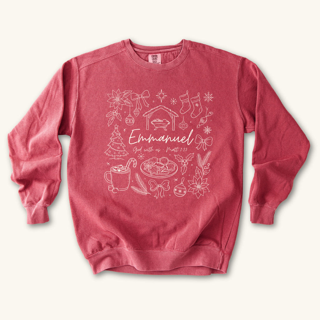 Crimson Christian Christmas sweatshirt with Emmanuel God with us script and Matthew 1:23 surrounded by doodles of a manger, stockings, a tree, cocoa and cookies.