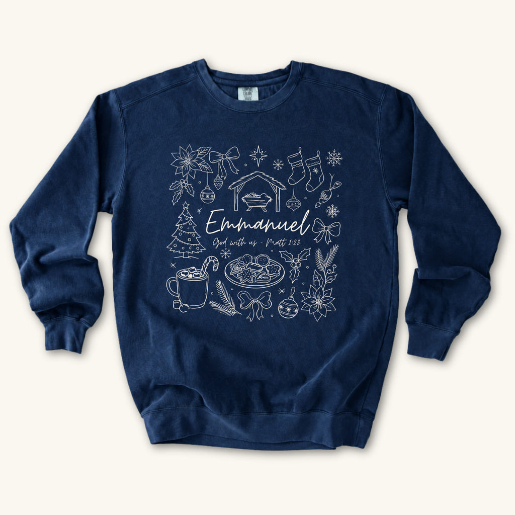 True Navy Christian Christmas sweatshirt with Emmanuel God with us script and Matthew 1:23 surrounded by doodles of a manger, stockings, a tree, cocoa and cookies.