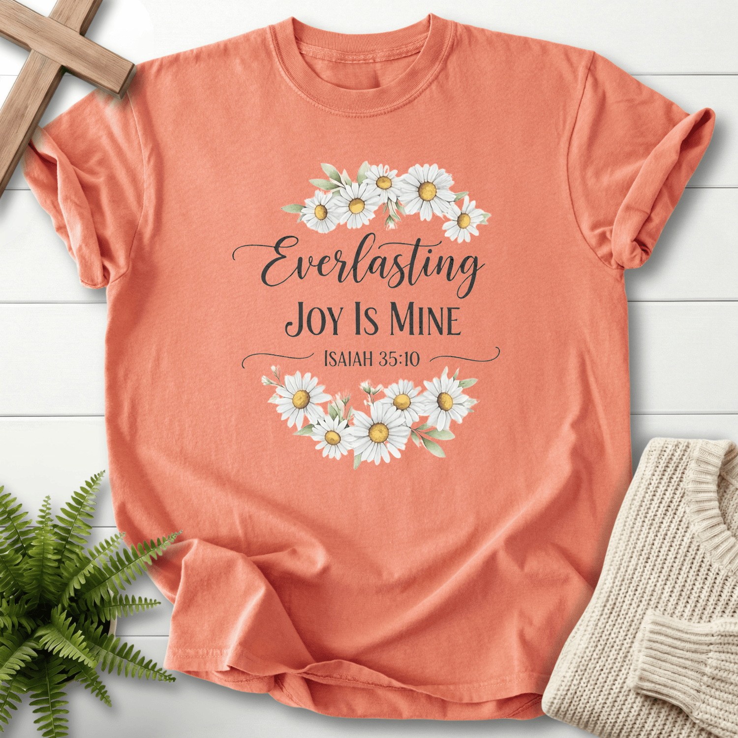 Terracotta women's faith t-shirt with a daisy wreath and scripture text, inspired by Isaiah 35:10.