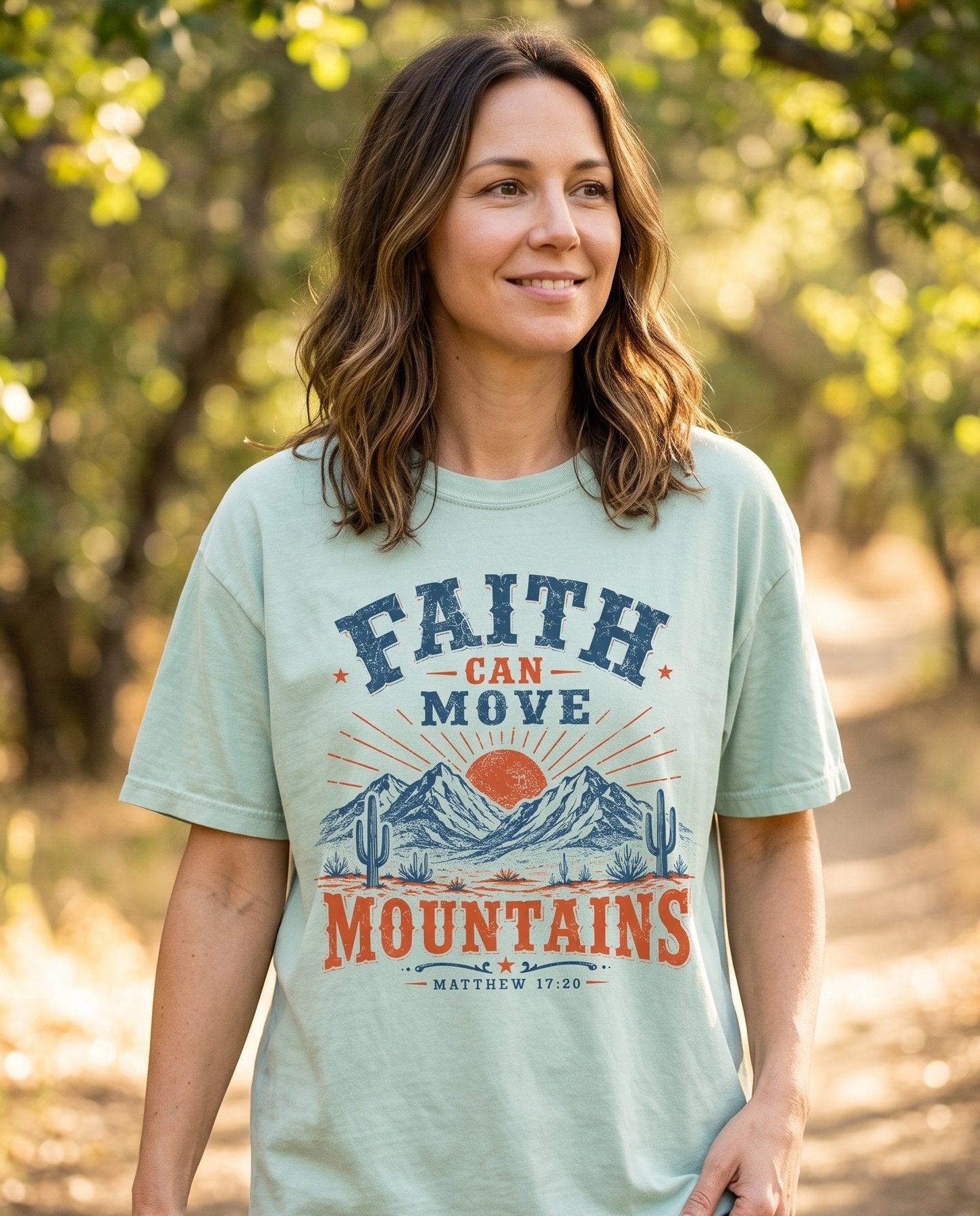 Faith Can Move Mountains Matt 17:20 – Bay women's Christian tee, lifestyle photo in nature trail – Vintage western-style badge with navy and burnt-orange lettering FAITH – Matthew 17:20 – She Wears Faith