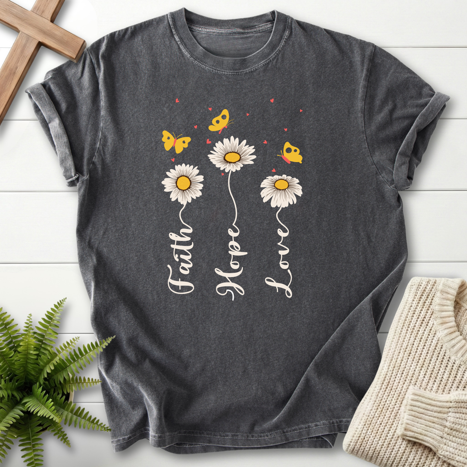 Pepper Christian t-shirt for women with three daisy stems forming cursive words and butterfly accents.
