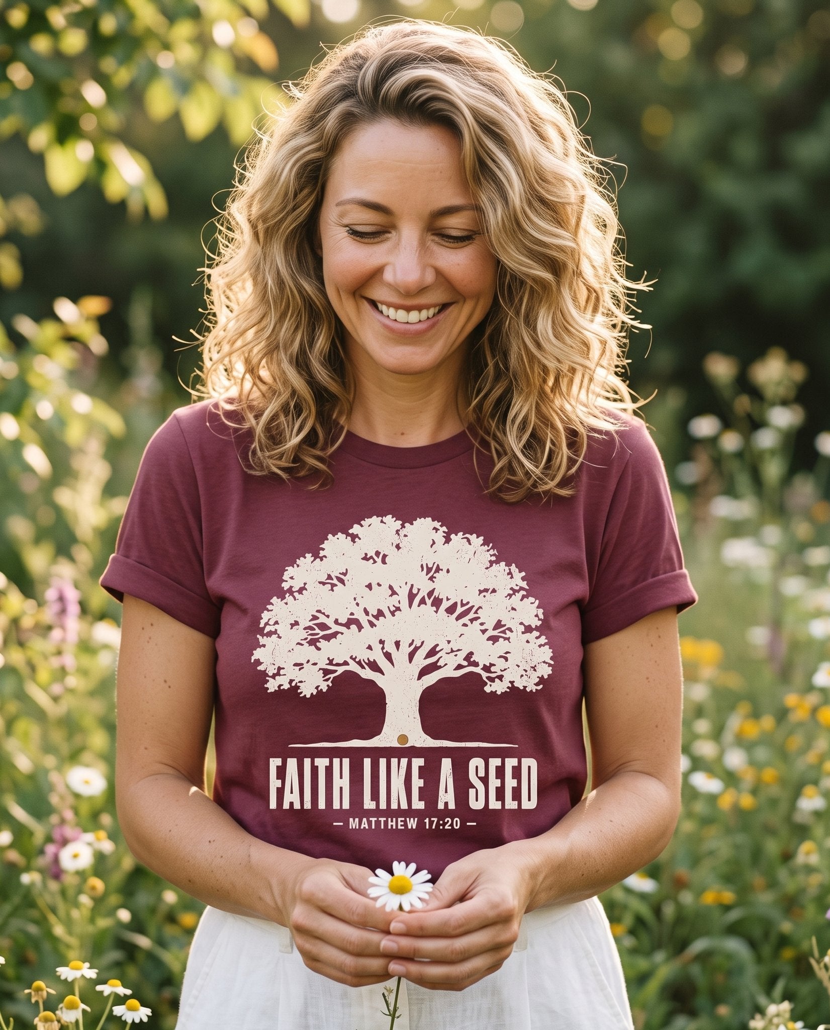 Faith Like a Seed – Berry women's Christian tee, lifestyle photo in outdoor garden – A cream silhouette of a full oak tree growing from a single seed at it – Matthew 17:20 – She Wears Faith