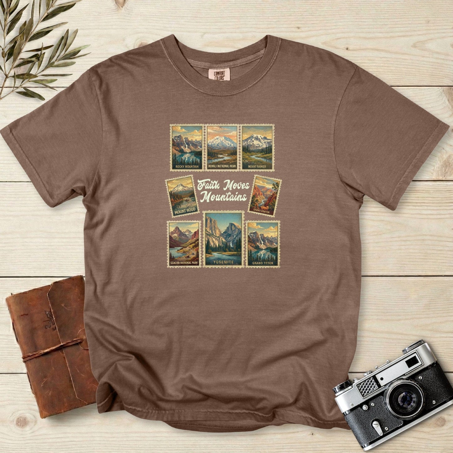 Comfort Colors 1717 espresso Christian women tshirt with retro national park stamp artwork and the uplifting phrase ‘Faith Moves Mountains.’ Outdoor travel style faith wear for Christian women who love nature and adventure